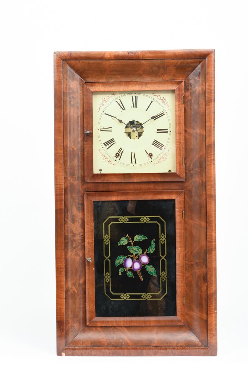 Ansonian 1842 American Ogee burled walnut case hanging wall clock with reverse painting on glass in the bottom panel. Eight day time and strike. The hanging wall clock is in good antique condition with wear consistent with use / age. The clock