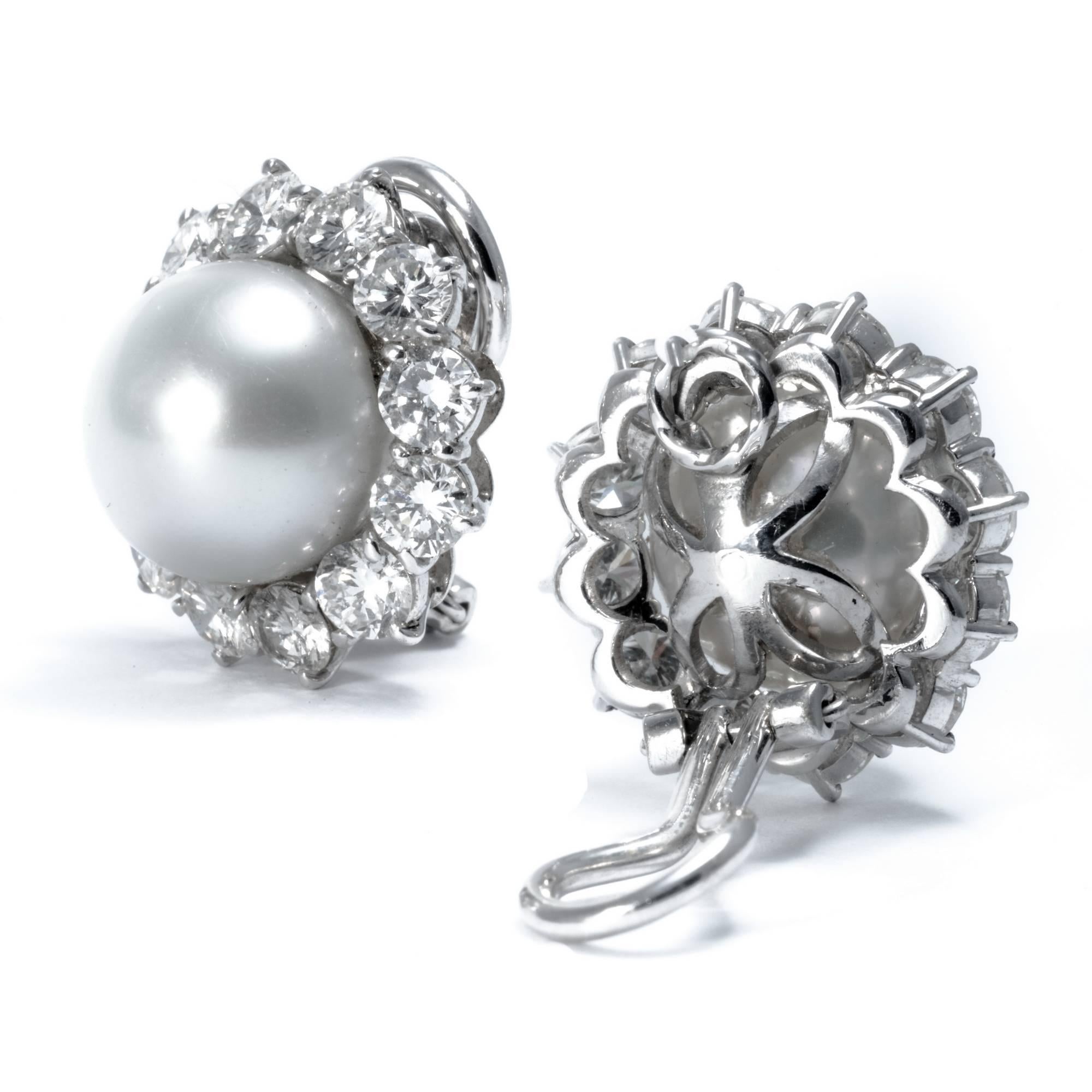  These stunning clip-on earrings feature 24 extra-white diamonds weighing approximately carats 4.50 and 2 natural highly cultivated Australian pearls diameter 12mm. Hand-crafted in 1960 by Ansuini in platinum, they are representative of the 