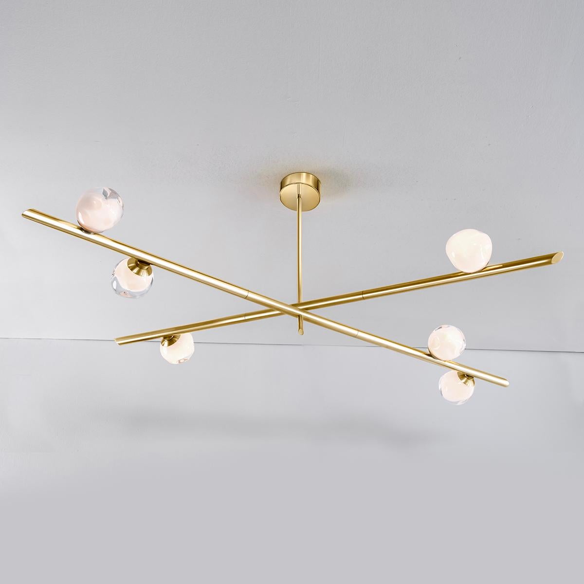The Antares ceiling light harmoniously balances the linear details of its intersecting arms with the organic form of its handblown glass shades. The first image shows the fixture in polished brass-subsequent pictures are in the standard satin