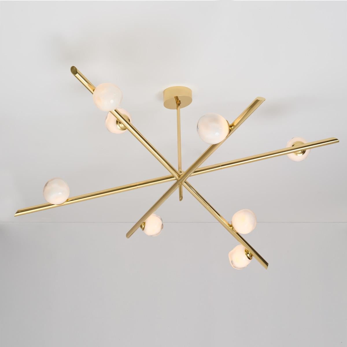 The Antares X3 ceiling light harmoniously balances the linear details of its intersecting arms with the organic form of its handblown glass shades. The first images show the fixture in our Polished Brass finish-subsequent pictures show it in a