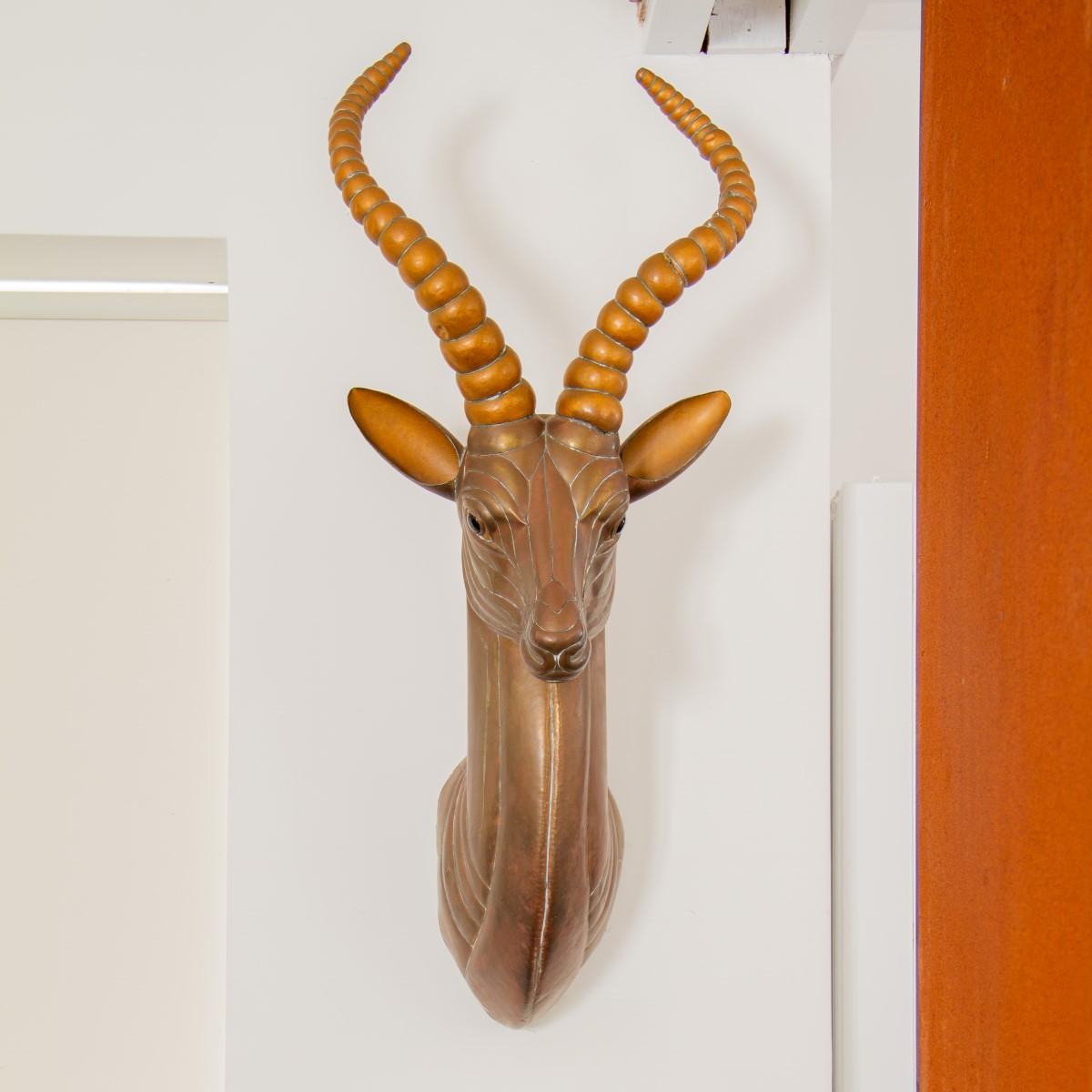 This fabulous antelope head sculpture is by the Mexican artist, Sergio Bustamante. This antelope head wall hanging sculpture, comprised of mixed brass and copper, with contrasting patination of the horns and ears, would work great in a within a