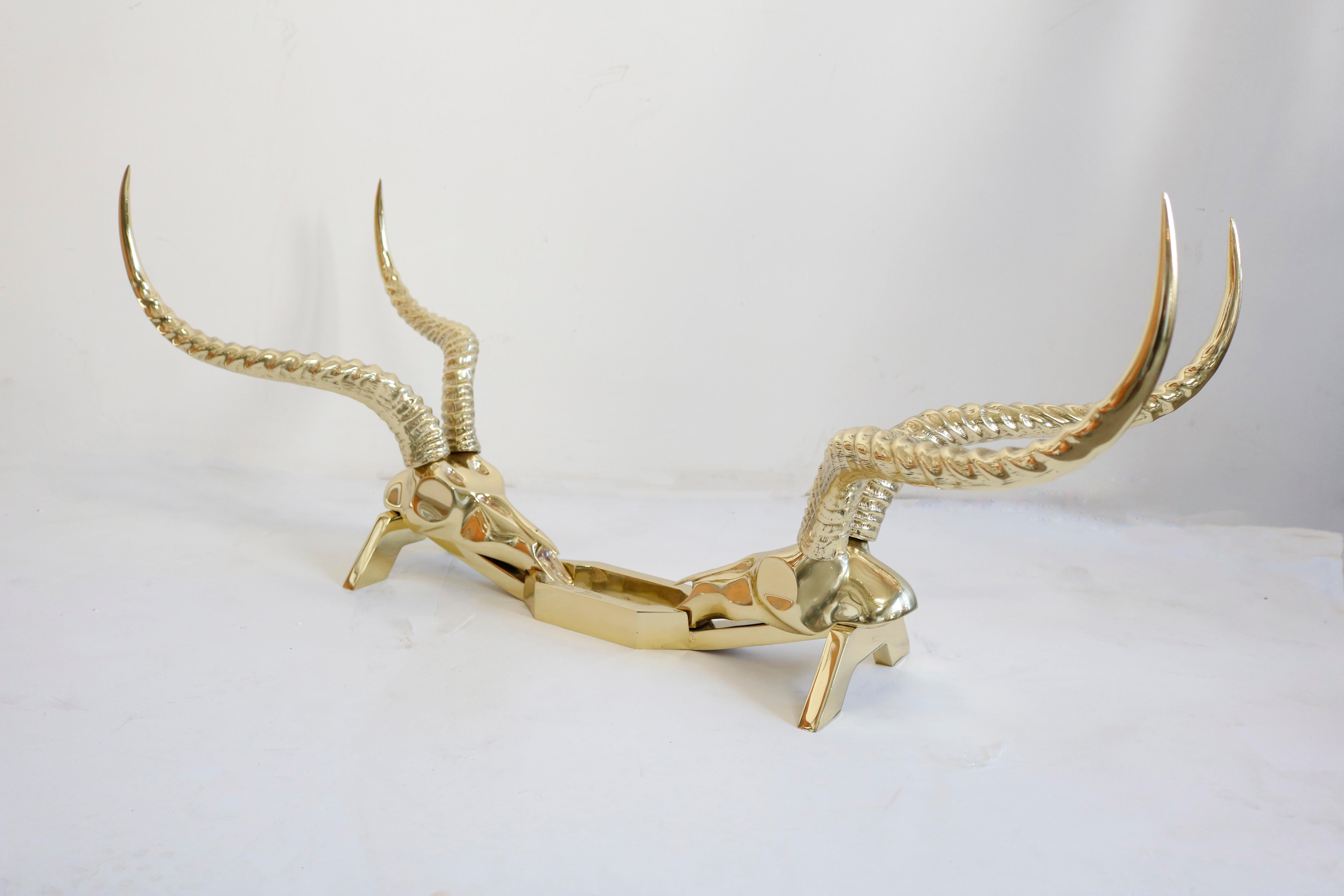 This coffee table features a solid sculpted brass base fashioned as two antelope skulls each with a stunning pair of horns. It has been created by Dikran Khoubesserian and manufactured by the “Fondica