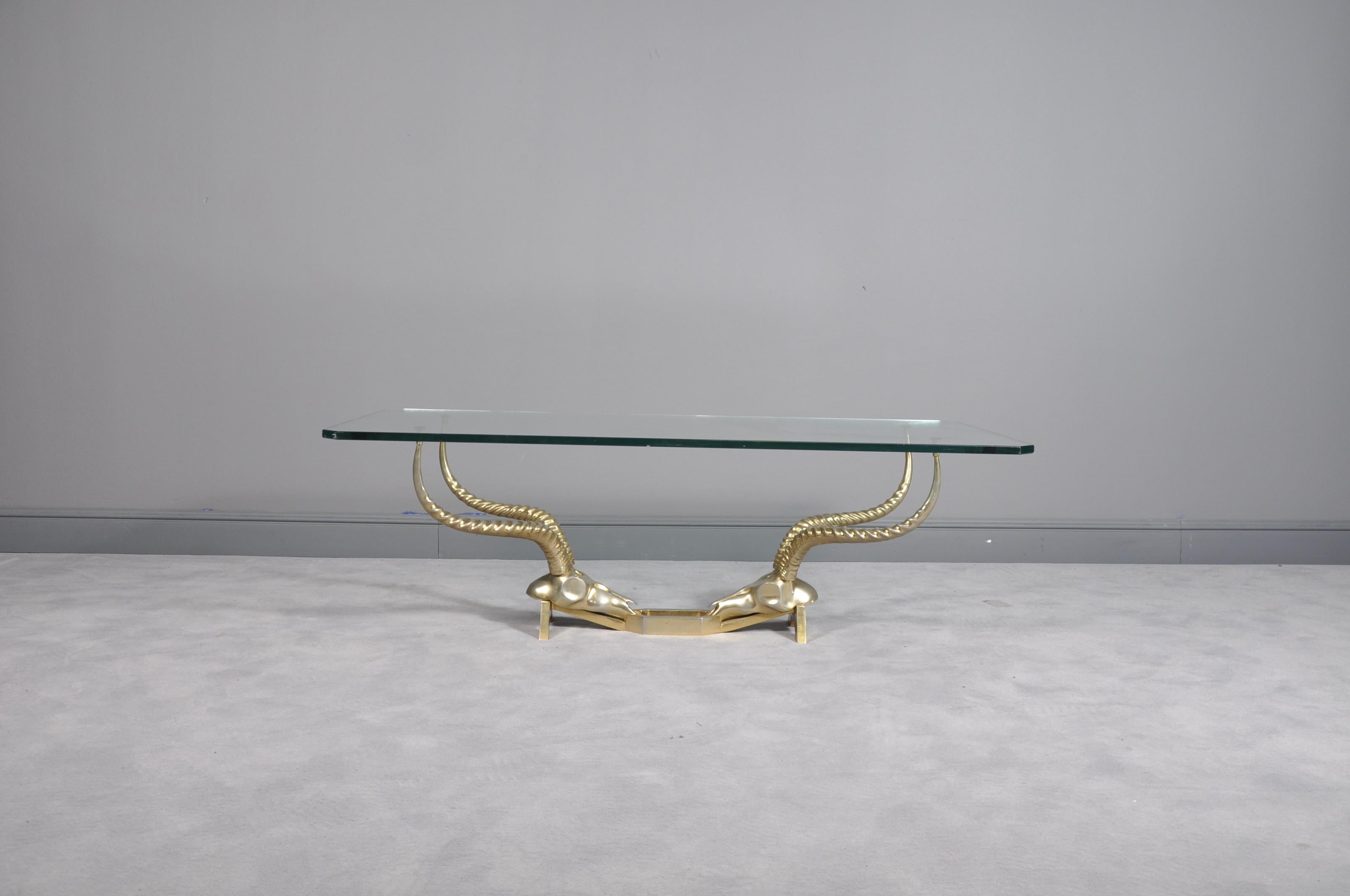 This coffee table features a solid sculpted brass base fashioned as two antelope skulls each with a stunning pair of horns.

Measures: W 130 / D 70 / H 42 cm

It has been created by Dikran Khoubesserian and manufactured by the “Fondica