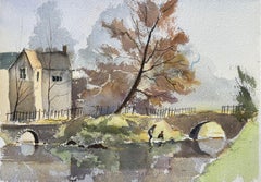 Acuarela impresionista británica de una casa junto al río y un puente de arco en otoño