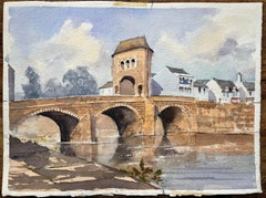 Acuarela impresionista británica de un puente de piedra iluminado por el sol y un pueblo ribereño