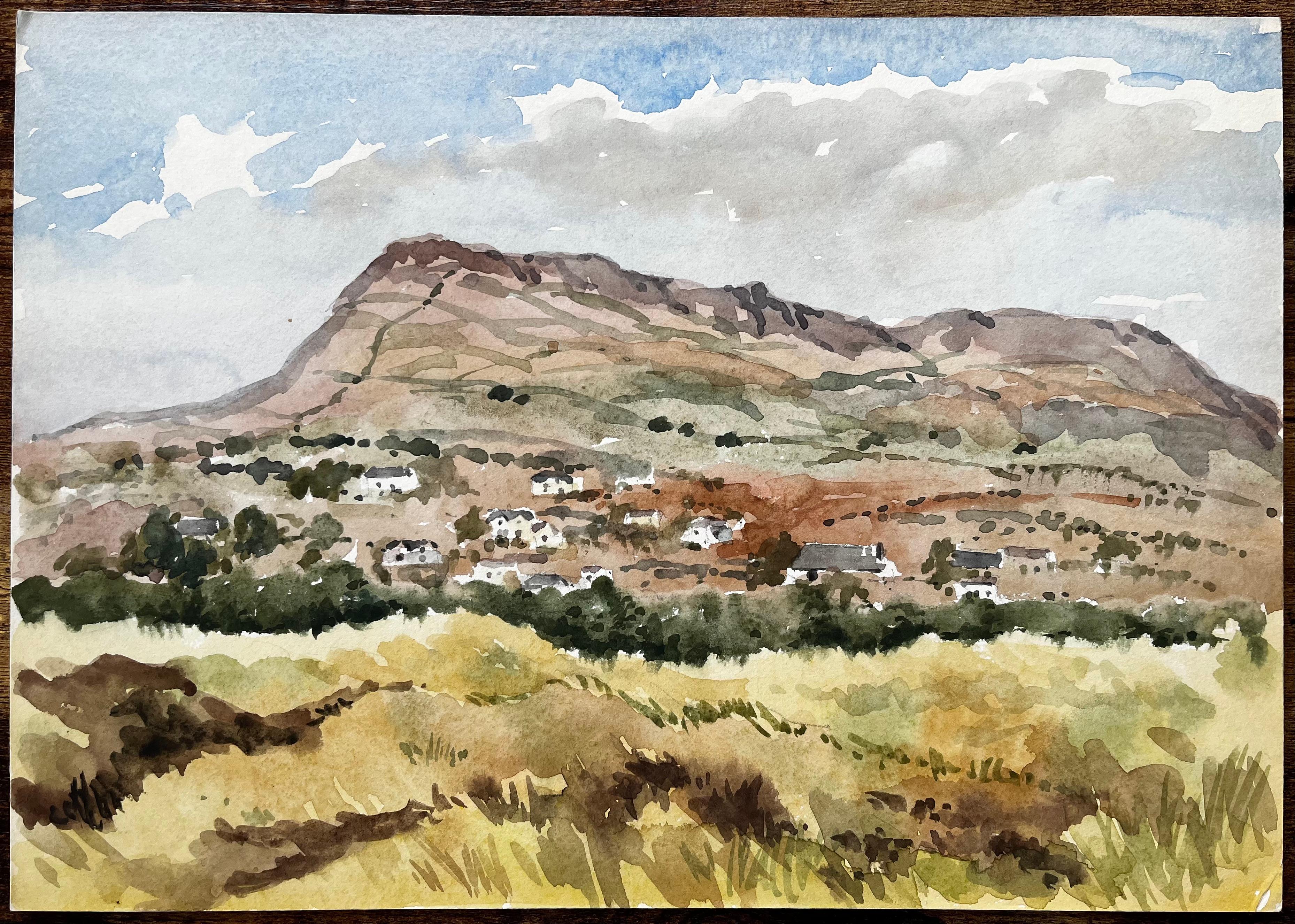 Bergdorf mit grasbewachsenem Vordergrund und blauem Himmel Schwarzer Felsensand Wales – Art von Anthony Herbert