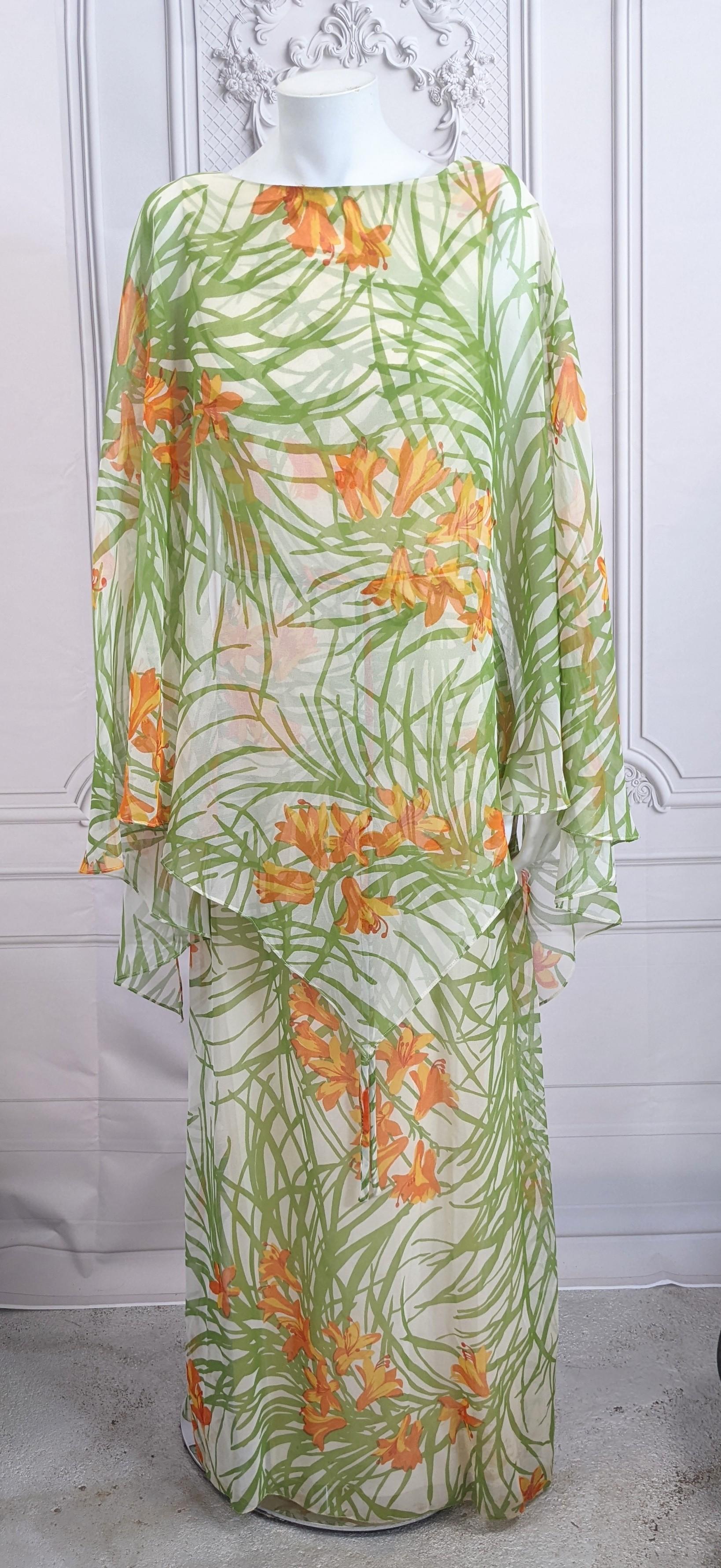 Flowy Anthony Muto chiffon gown with overall morning glory and foliage print. A simple one piece wide necked sheath gown with wrapped back bodice has a large triangular scarf attached along the front neckline. Rayon. Back wrap with zipper. 1970's