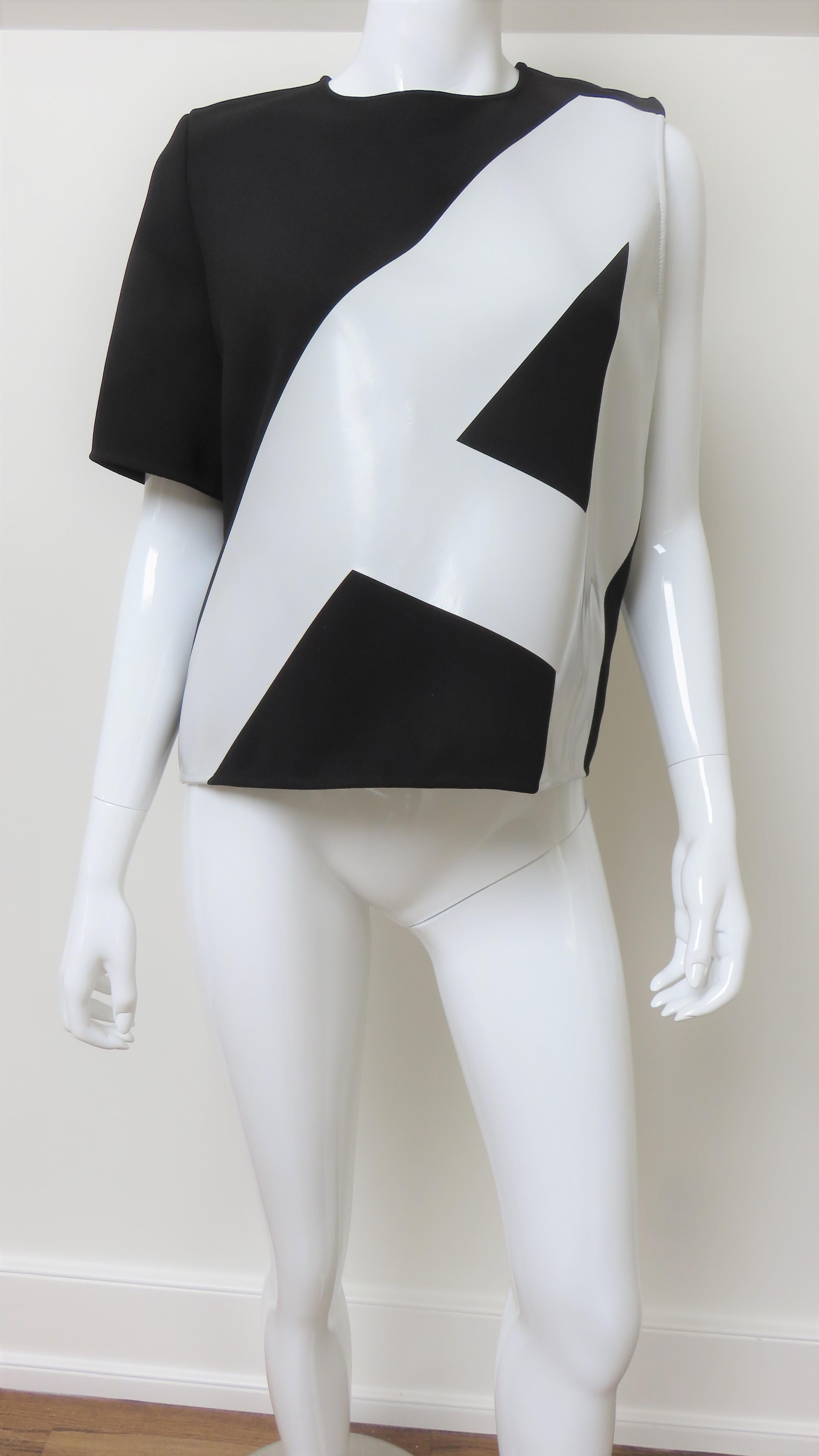 A fabulous black and white geometric top from Anthony Vaccarello.  It has a crew neckline, one short sleeve and a white shiny tilted capital A on the front.  It has a back zipper at the neck. There is a small pen mark at the side seam, priced