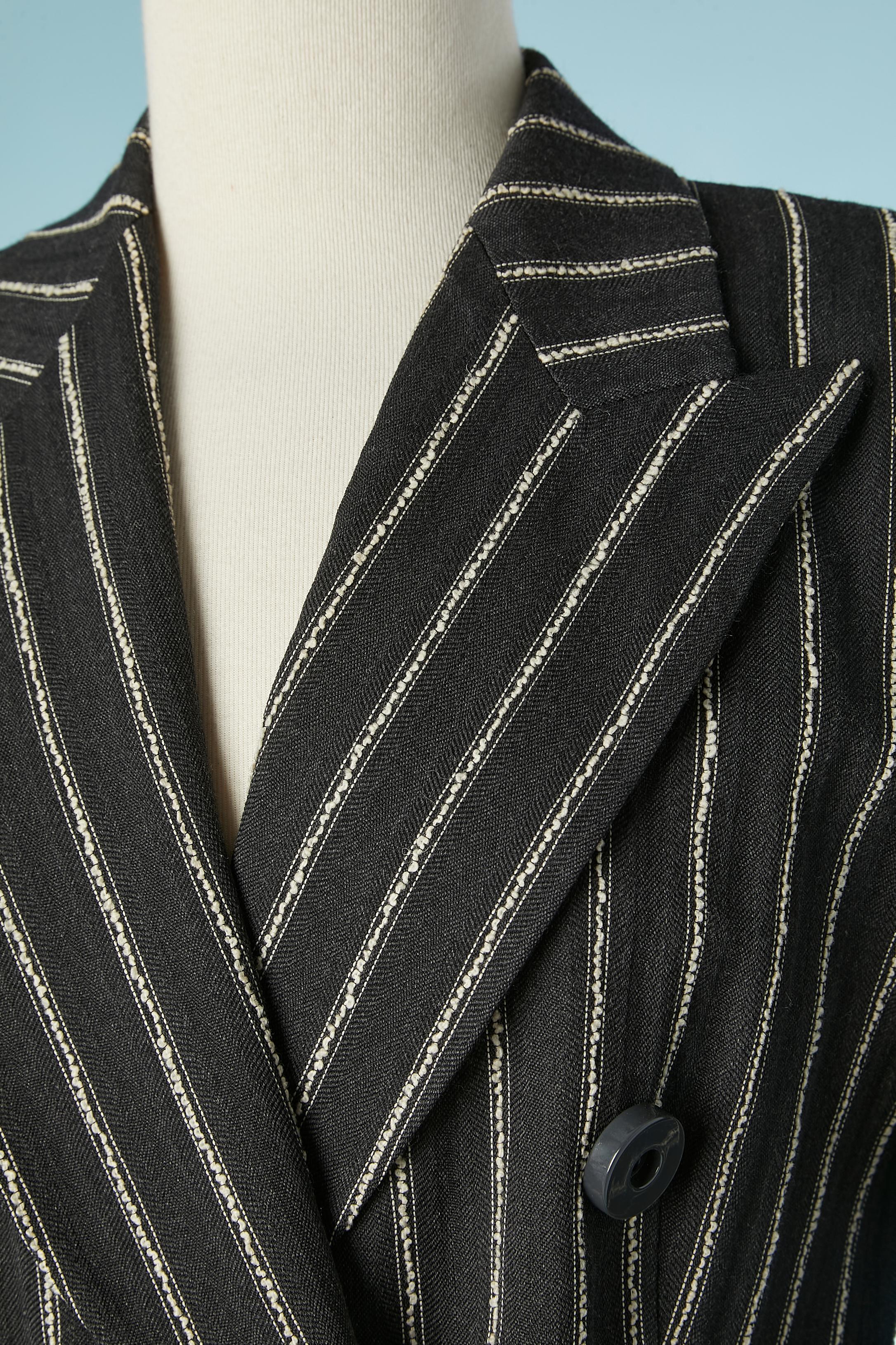 Anthracite striped wool and cotton  double-breasted skirt suit. Fabric composition: 77% wool, 23% cotton.Lining: 63% acetate, 37% cupro. 
Shoulder pads. Pockets on both side on the jacket. 
SIZE 44 (It) 8 (Us) 