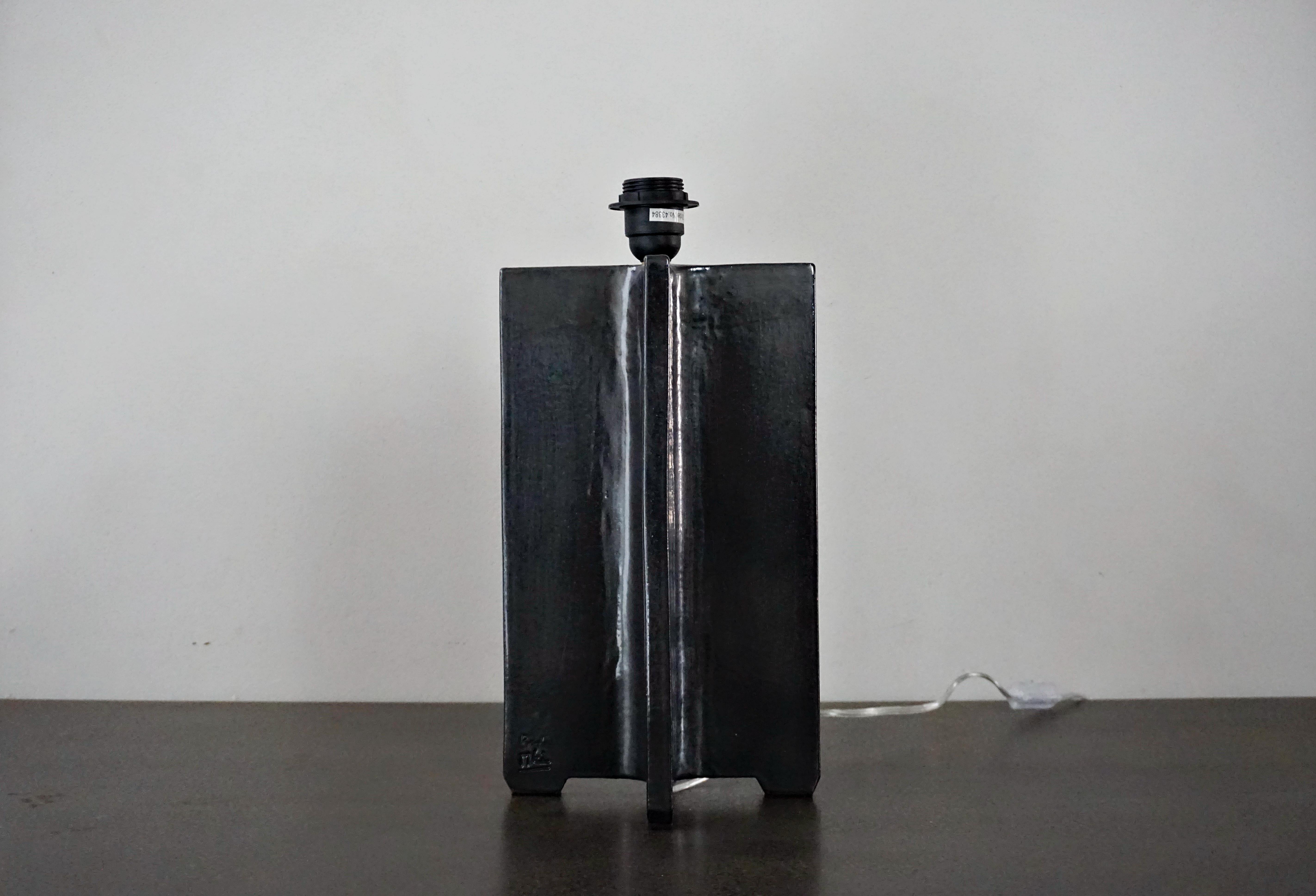 Lámpara de mesa de cerámica hecha a mano, diseñada y firmada por el artesano Rulo y el artista Manolo Eirin. Pieza vitrificada en negro. La conexión eléctrica de la lámpara es apta tanto para el mercado americano como para el europeo (la bombilla y