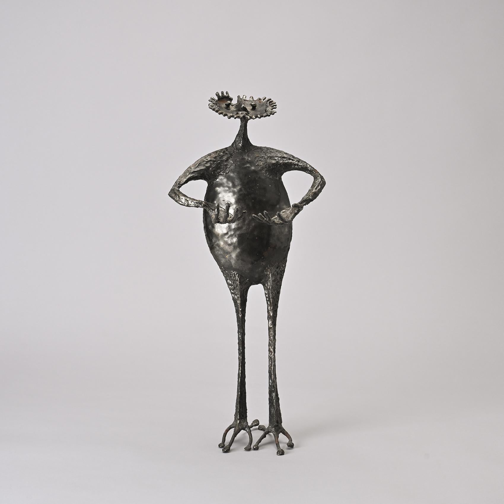 Questa scultura unica di Michel Anasse incarna l'universo libero ed espressivo dell'artista con poesia e umorismo.

La figura, con il suo corpo ovoidale e le braccia tese, presenta una testa coronata da punte che ricordano una criniera solare. Il