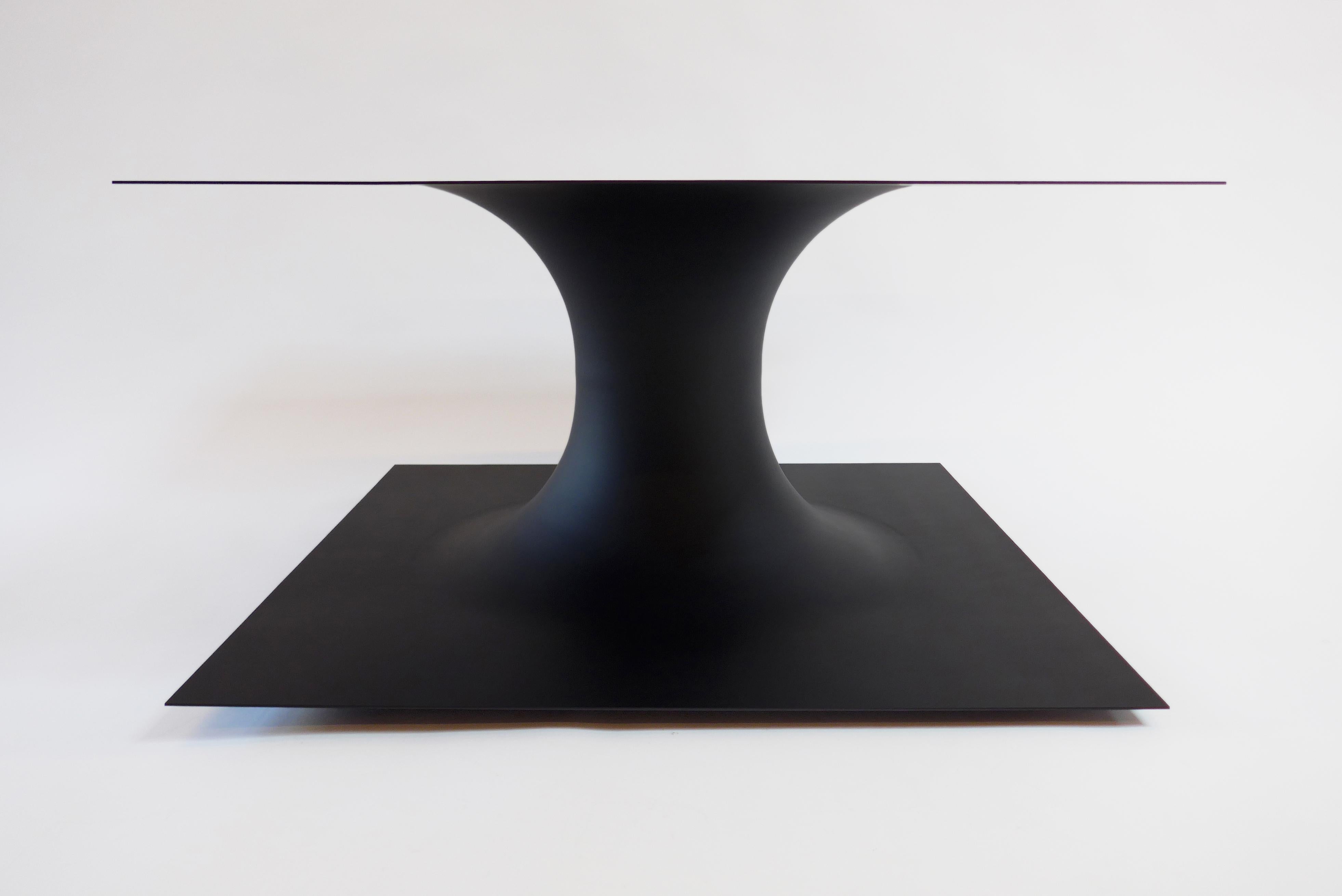 Anti-table is a Minimalist furniture piece designed by Brooklyn-based Erickson Aesthetics in ultra matte black enameled spun steel which evokes a three dimensional diagram of a wormhole. The simplistic form of this table is a composite of
