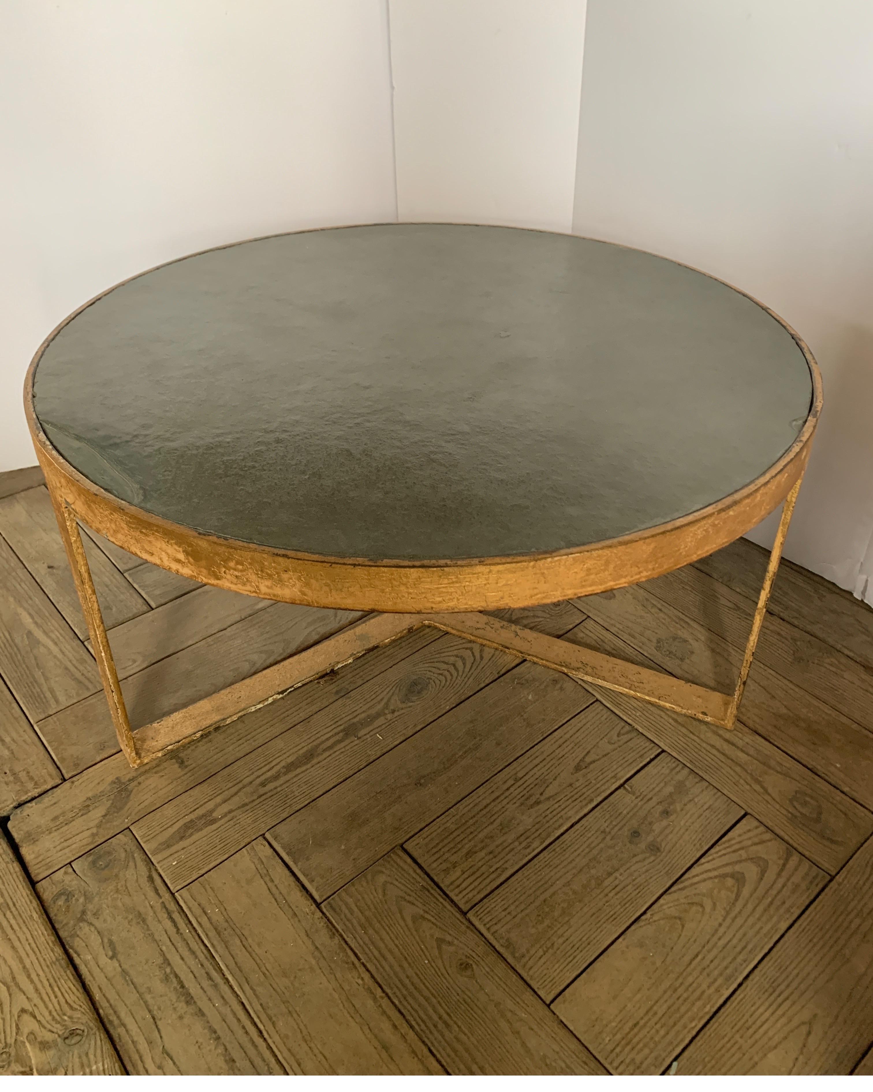 This is a heavy duty coffee table with gold finish and greenish gray slate top. We make them in our warehouse in Europe. They have a distressed look as if they have age both the gold finish as well as the slate.