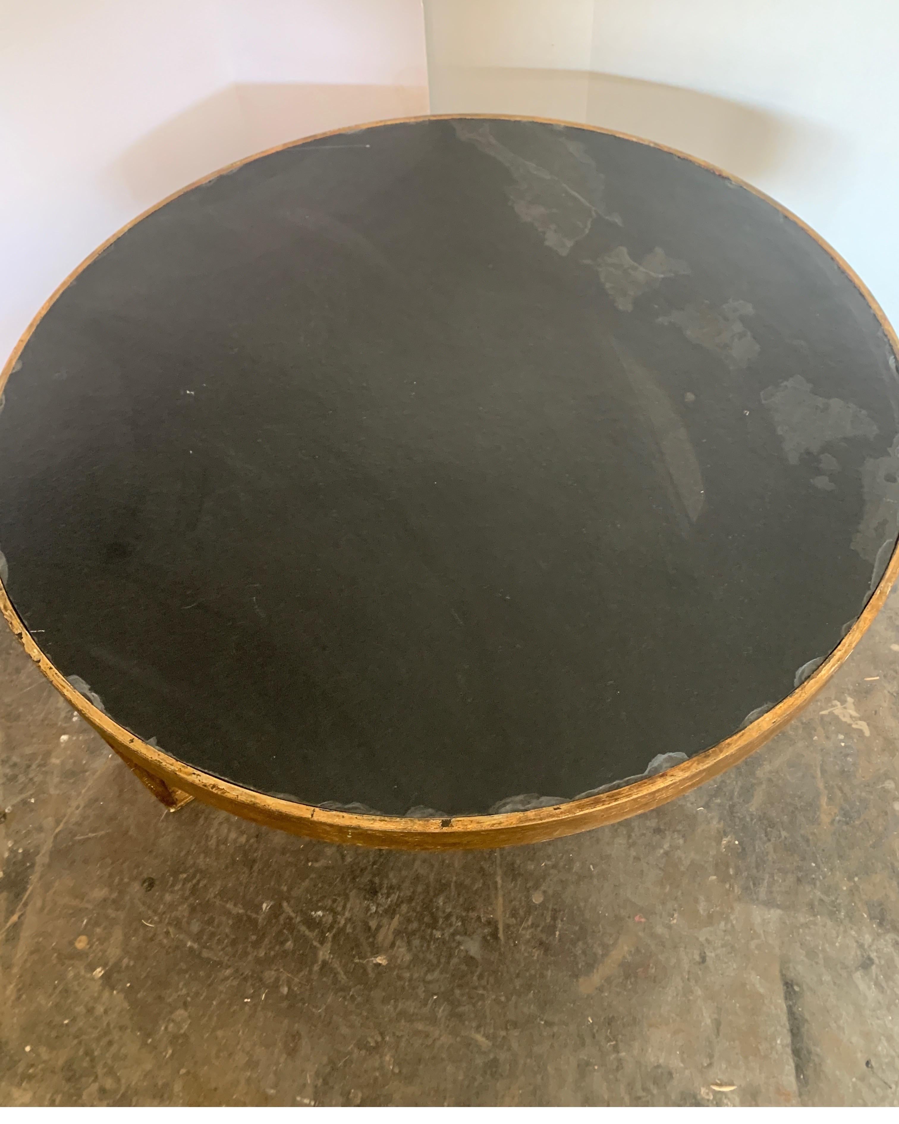 We fabric this table in various sizes. The is perfect between two chairs are as a small coffee/cocktail table.
It's very heavy iron, finished with gold and a beautiful black slate top is inset.