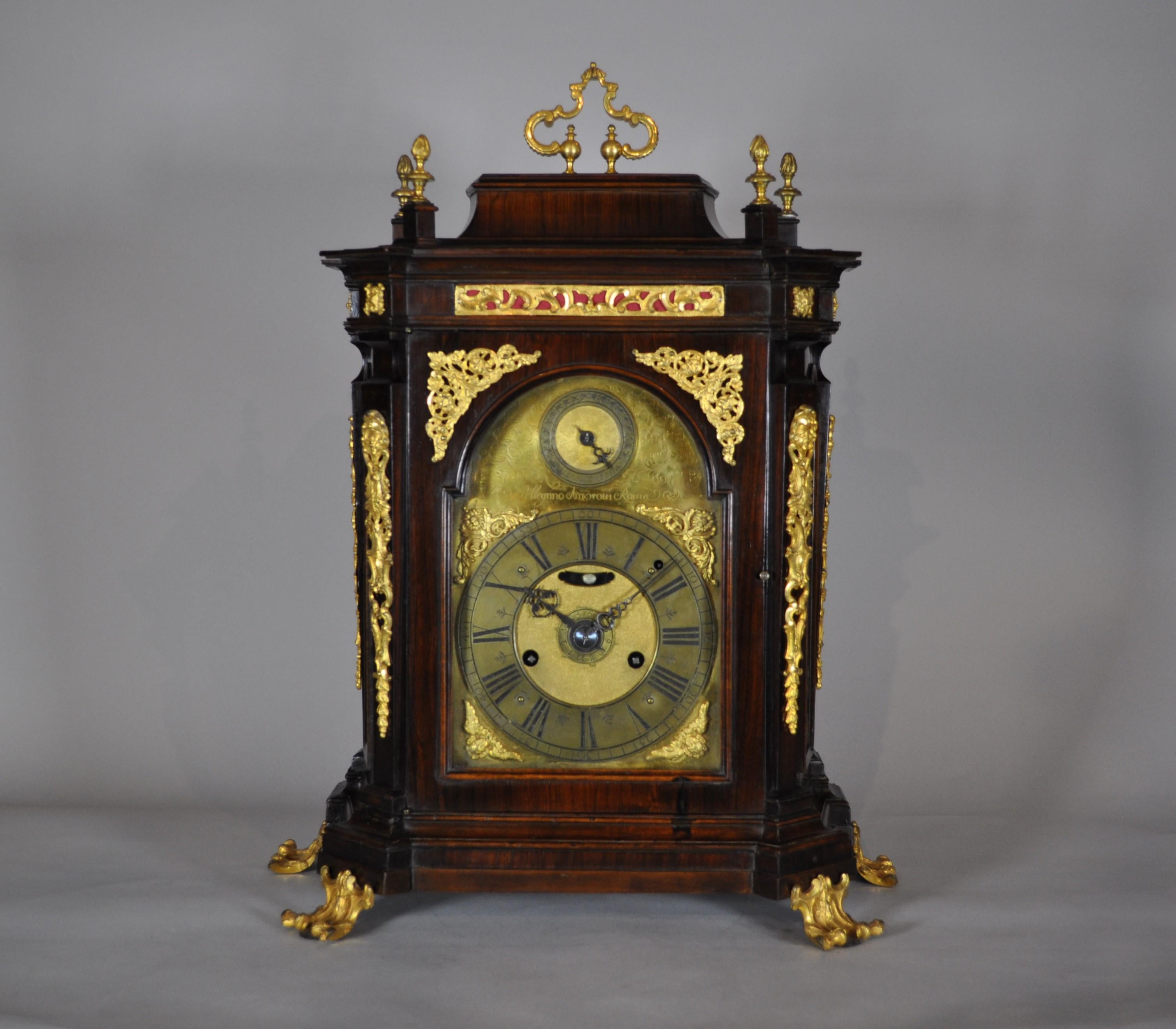 Raro reloj romano de sobremesa.
Caja de madera de nogal y frisos de bronce dorado finamente trabajados.
Esfera de latón dorado con banda horaria y esfera central de alarma.  Marque 'a las 12 en punto' para 'ring-noise' (exclusión de