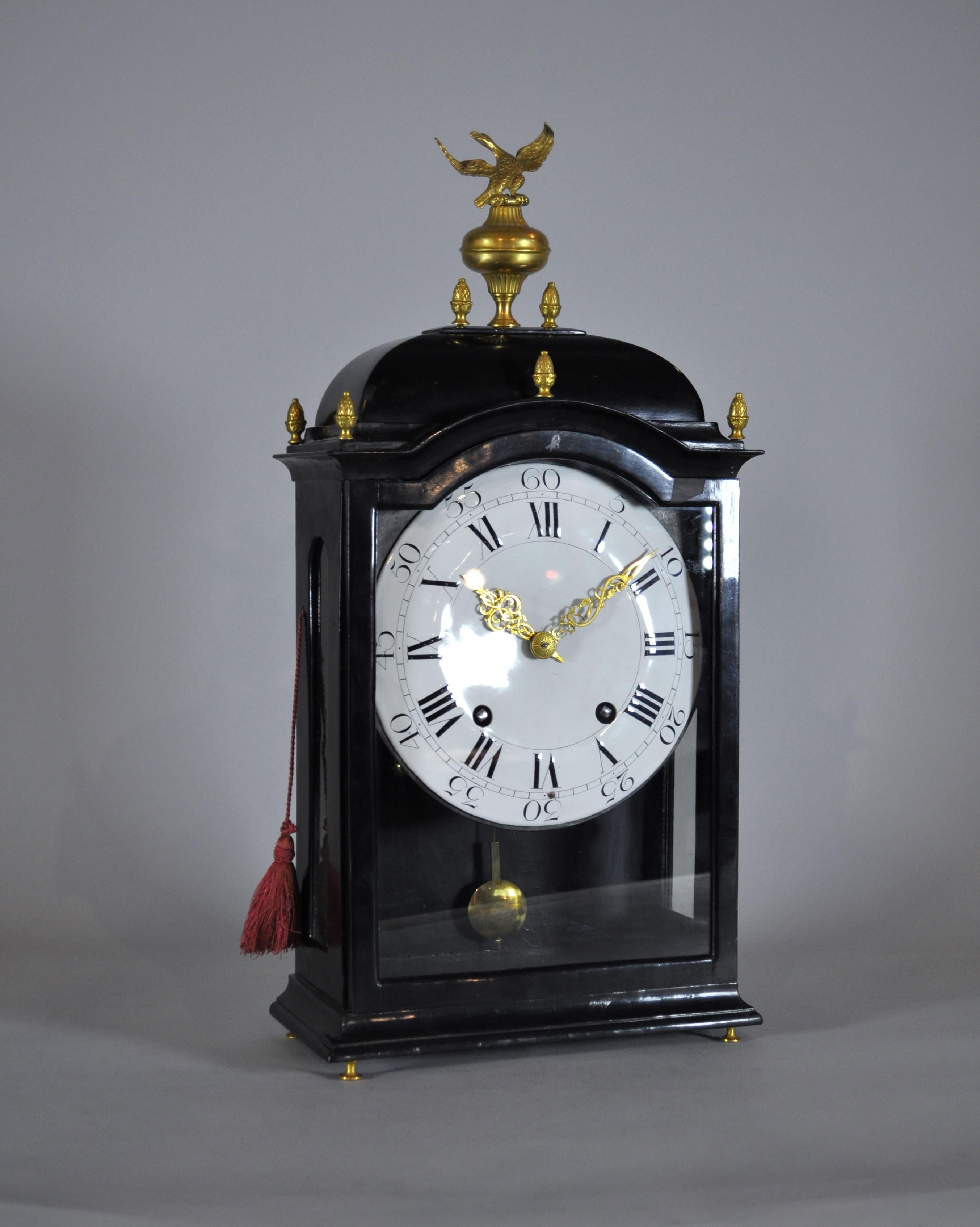 ANTIQUE SWISS GRANDFATHER CLOCK WITH CHIME
Ebonized wood case with gilded bronze eagle on top and gilded bronze pinnacles. Door with glass on the front to access the charging holes. Wooden door at the back to access the movement.
White enamel dial