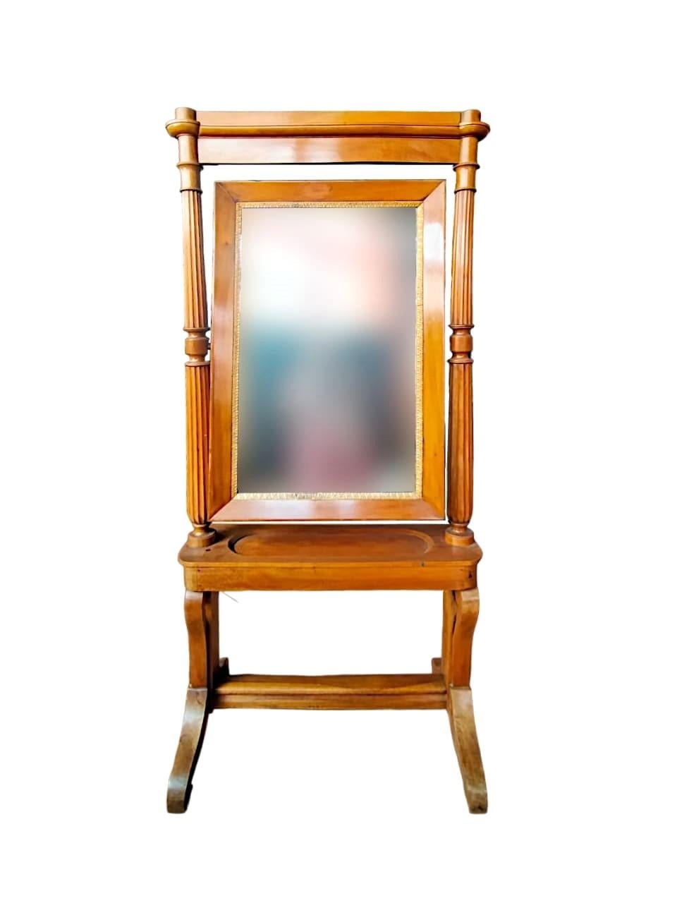 Antike neoklassische Psyche in blondem Nussbaum mit eleganten Säulen mit geschnitzten Rillen.

Der Spiegel ist mit einem Rahmen mit vergoldeten Akanthusblättern verziert
Auf der Innenseite der Schublade steht das Datum der Herstellung: 1821
Maße: H