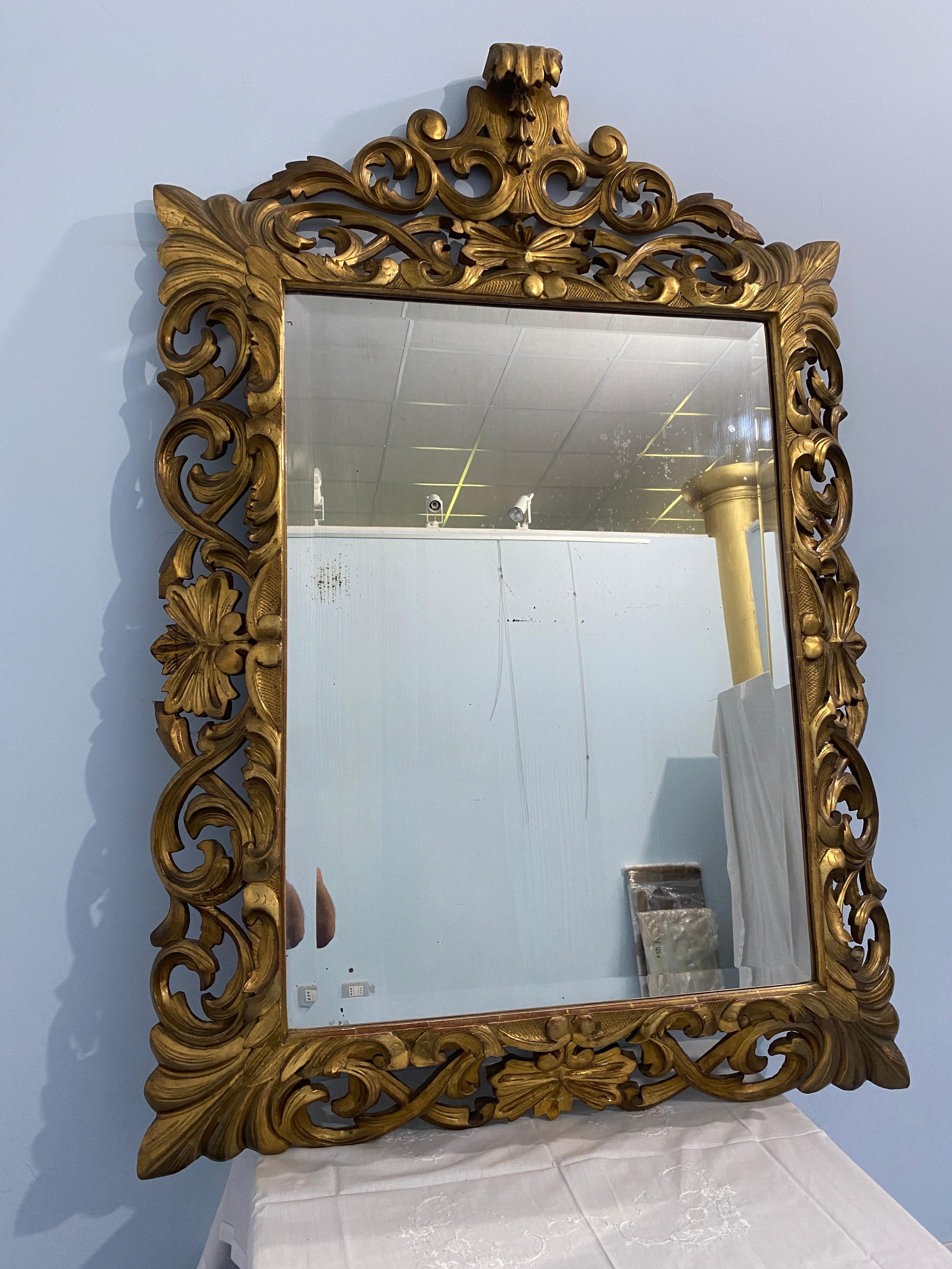 Splendida specchiera antica in legno intagliato dorato a foglia d'oro, con cimasa nella parte superiore. La specchiera a piacere può anche essere appesa in senso verticale in quanto la cimasa si può staccare. Trattasi di uno specchio di grande