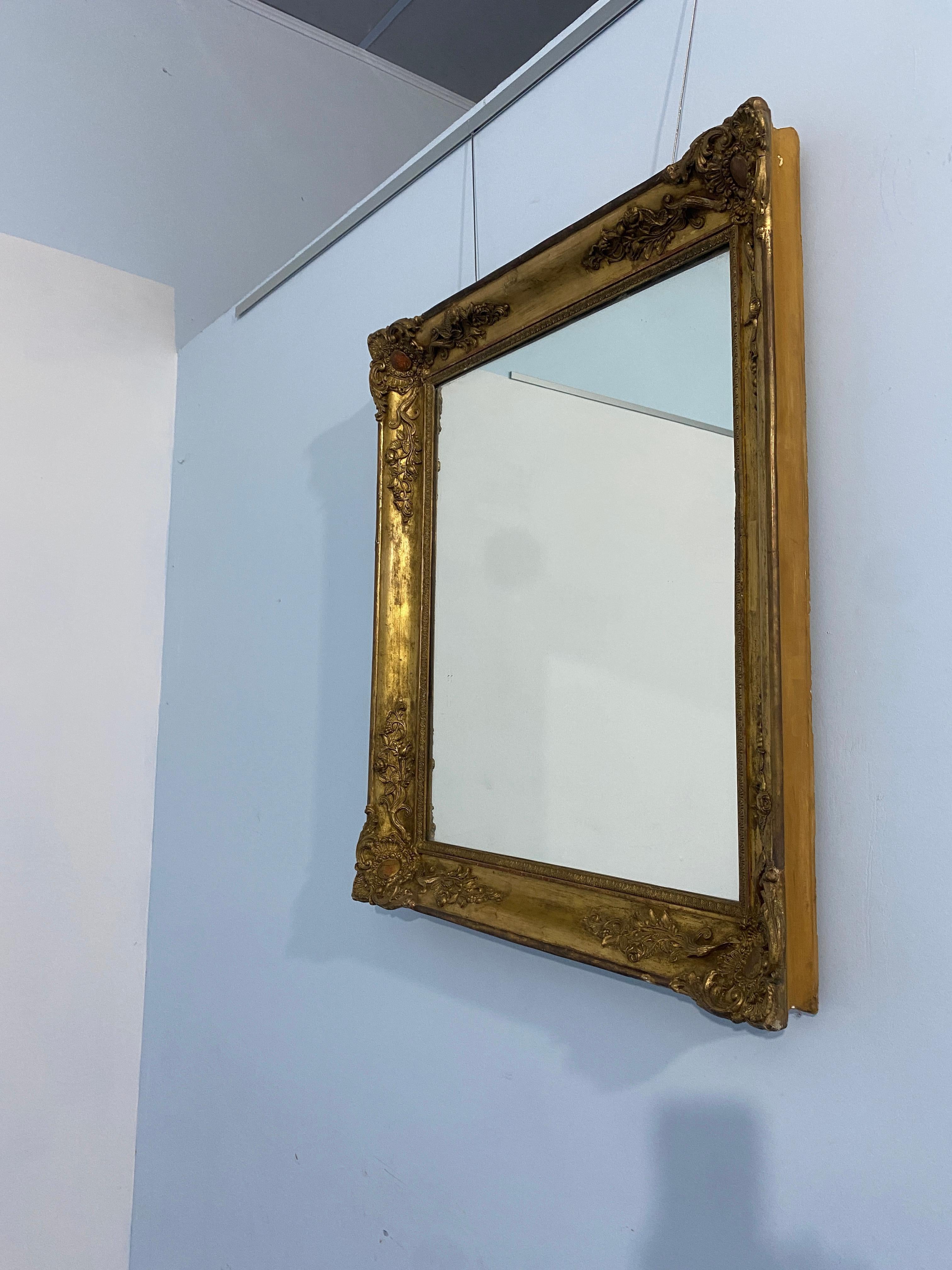 Miroir ancien français à feuilles d'or doré de l'époque Napoléon-Troisième, 1870. Les décorations raffinées qui ornent les quatre coins du cadre sont caractéristiques de l'époque.
L'état est très bon pour être encore d'origine