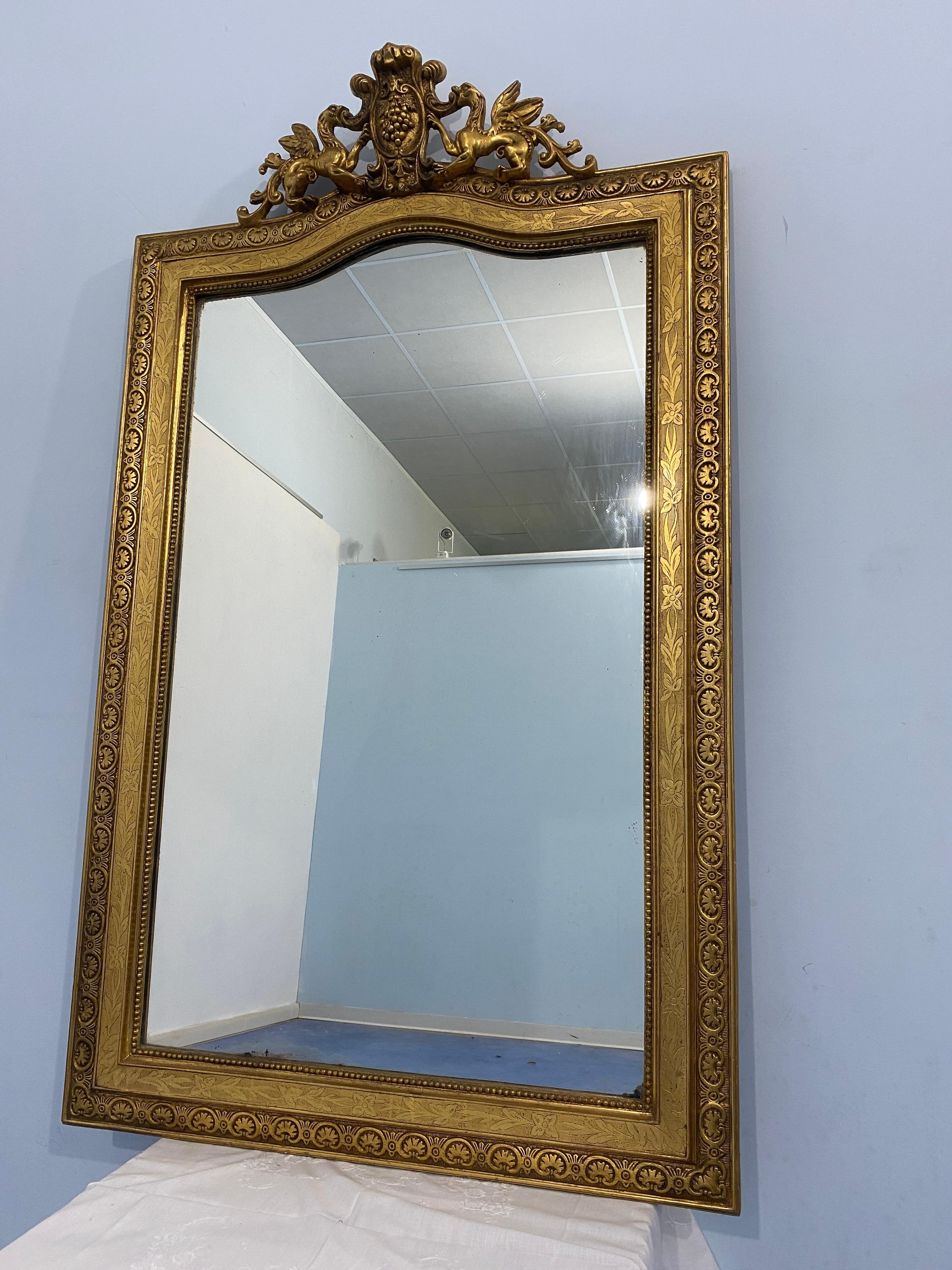 Antique French gilded wood mirror with gold leaf Louis Philippe era, 1850s, classic of the period the shaped frame movement at the top,adorned in turn with a splendid cymatium.The frame  of great executive quality , it is enriched in the central