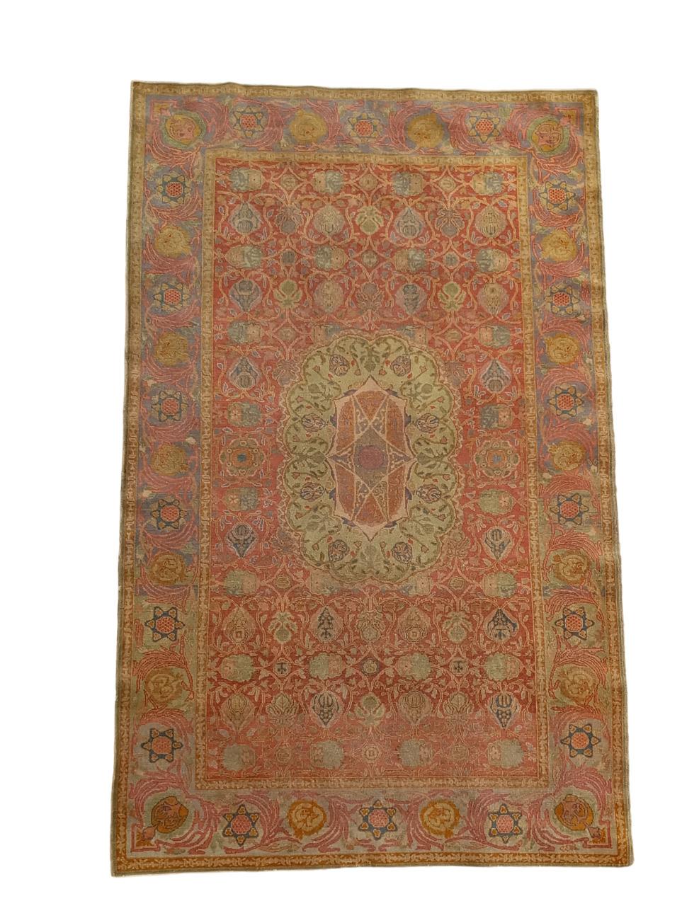 Tappeto antico Israeliano Bezalel prodotto nei primi anni del XX secolo presso la New Art School di Gerusalemme. Questo esemplare è ricco di simboli Ebraici. Realizzato con vello di lana, trama e ordito in cotone. Colori tenui, che variano dal rosso