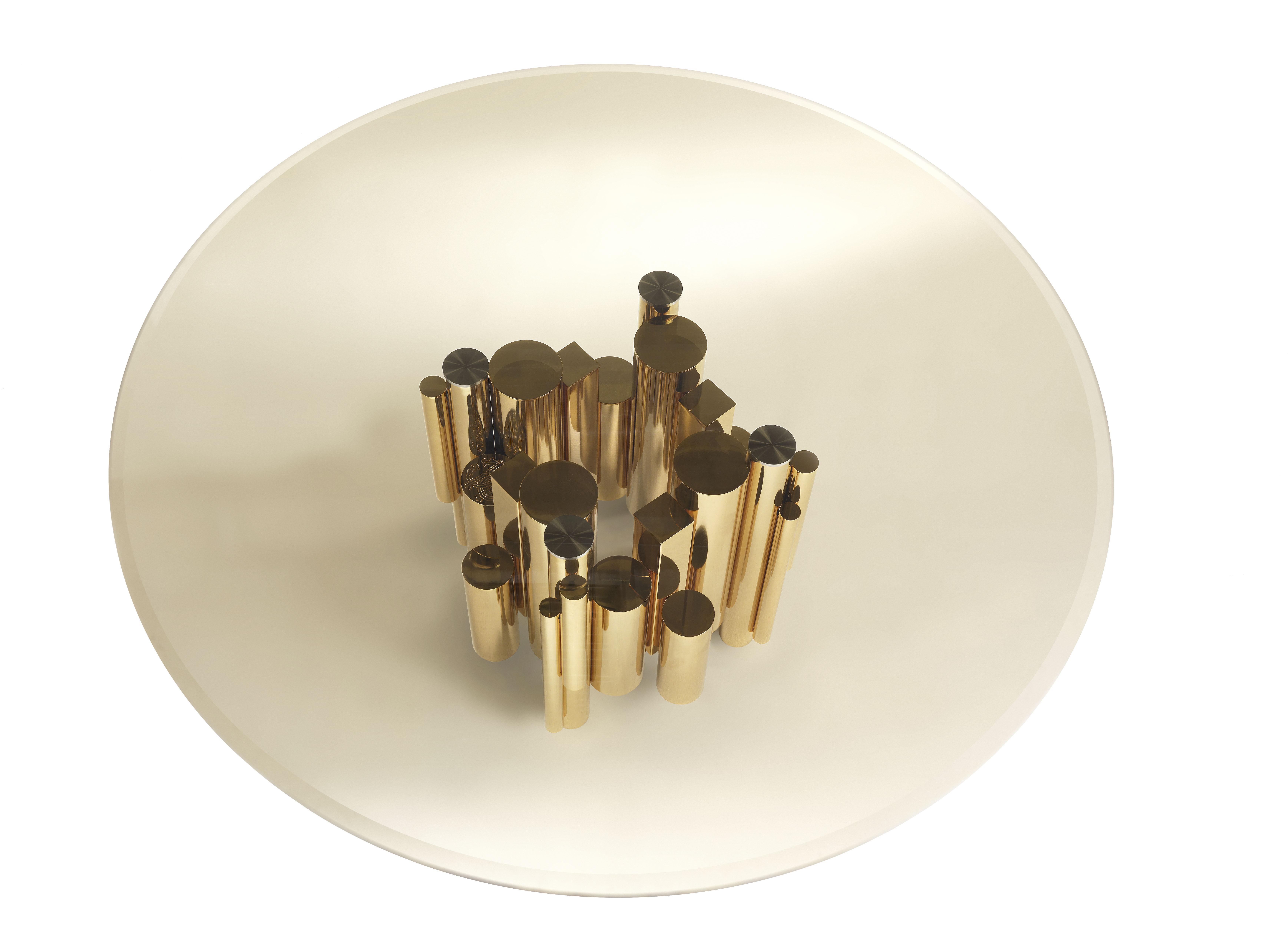 Elegancia, encanto y contemporaneidad: en un inesperado juego de luces y transparencias, la extraordinaria escultura de oro brillante de la base de la mesa brilla a través del tablero de cristal ahumado. Un elemento escénico y de impacto para un