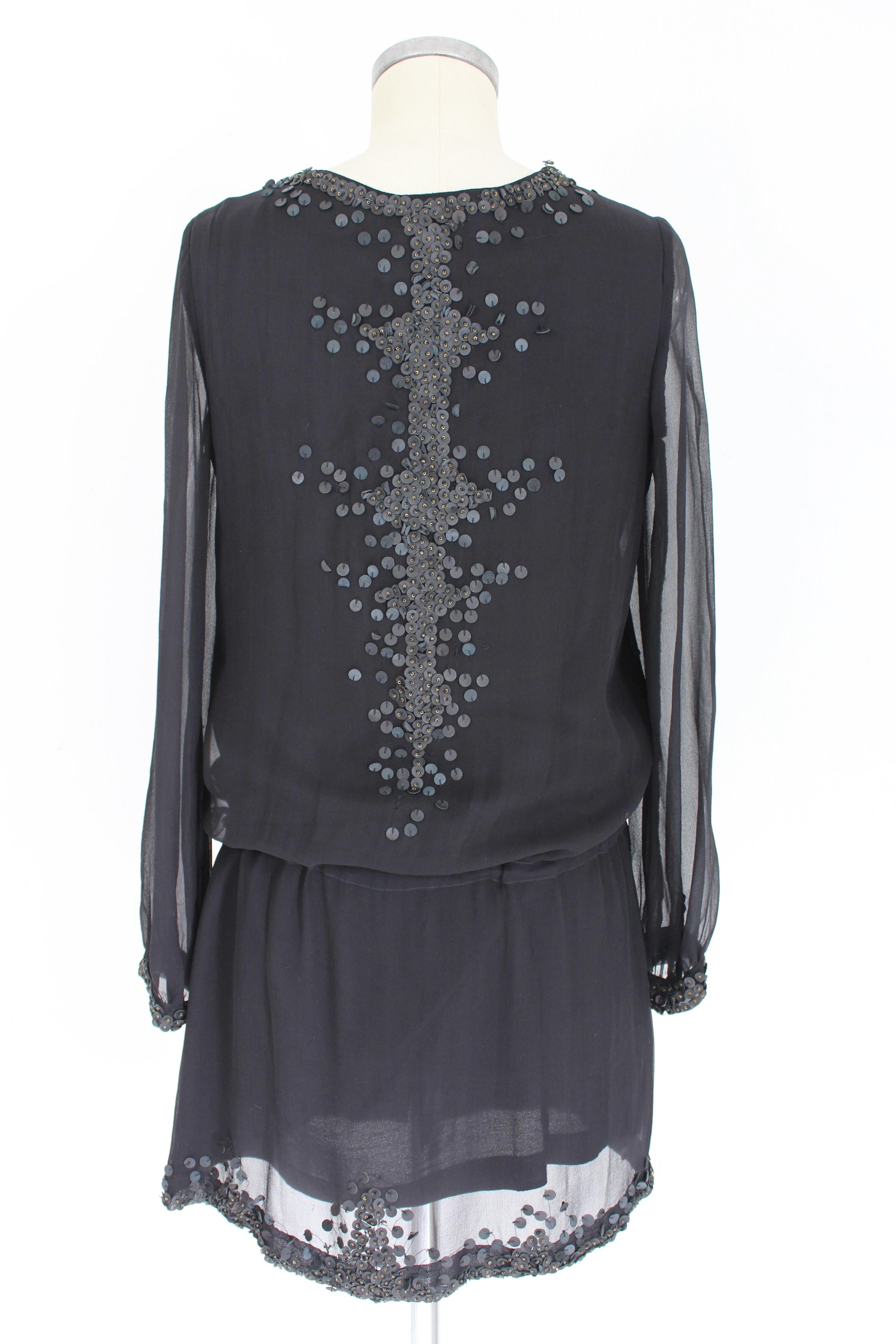 Kurzes Vintage-Kleid von Antik Batik für Frauen. Schwarze Farbe, 100% Seide, von Hand genähte Applikationen aus 100% Leder. V-Ausschnitt, elastischer Taillengürtel, gefüttert. 1990s. Entworfen in Frankreich, hergestellt in Indien. Ausgezeichneter