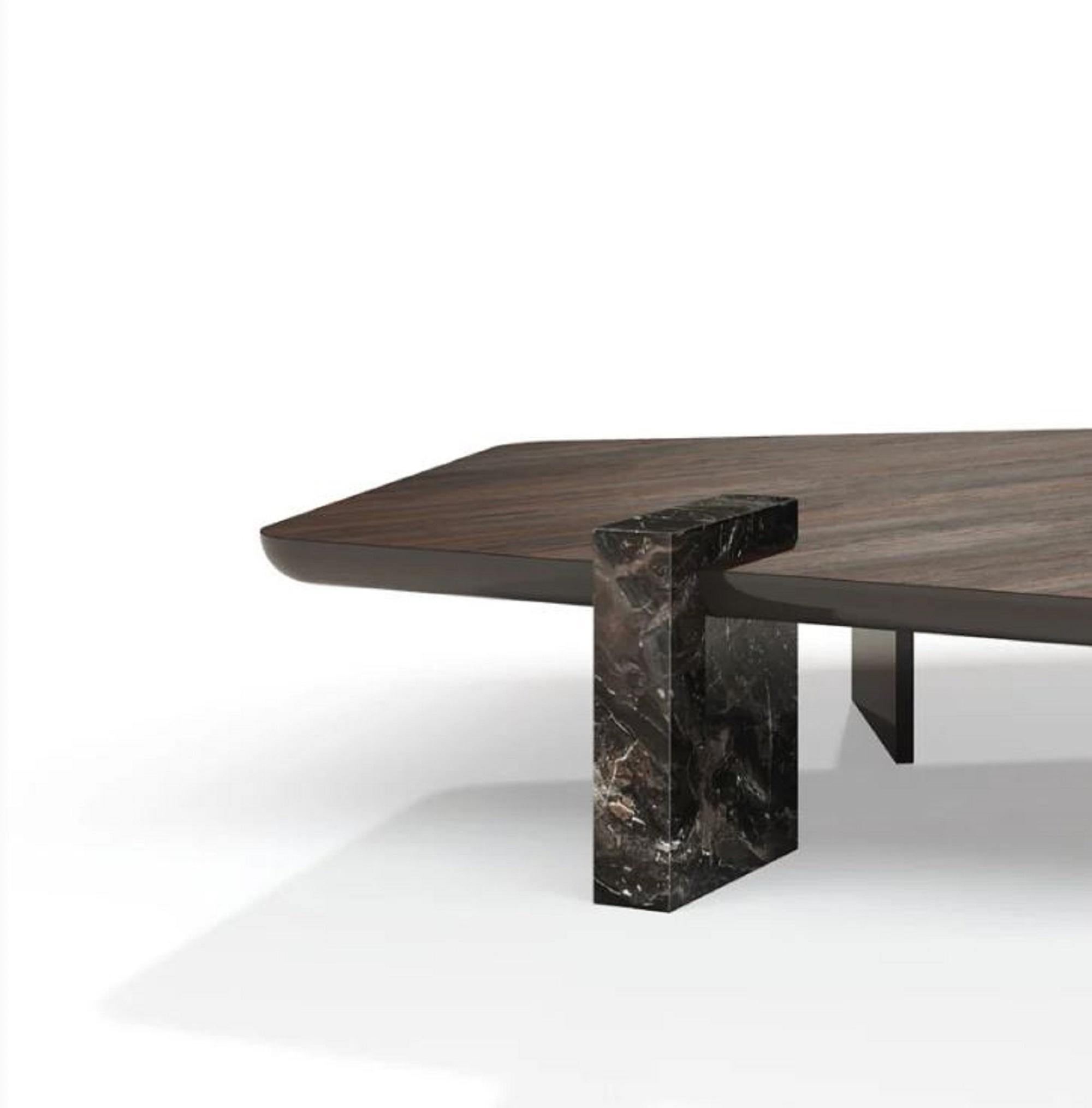Antinomia, designed by Adele Martelli, is a coffee table that harmonizes contrasting elements. Its structure consists of a monolithic base – made of veneered, lacquered panels or solid marble – and a sculptural top in round or pentagonal form. The