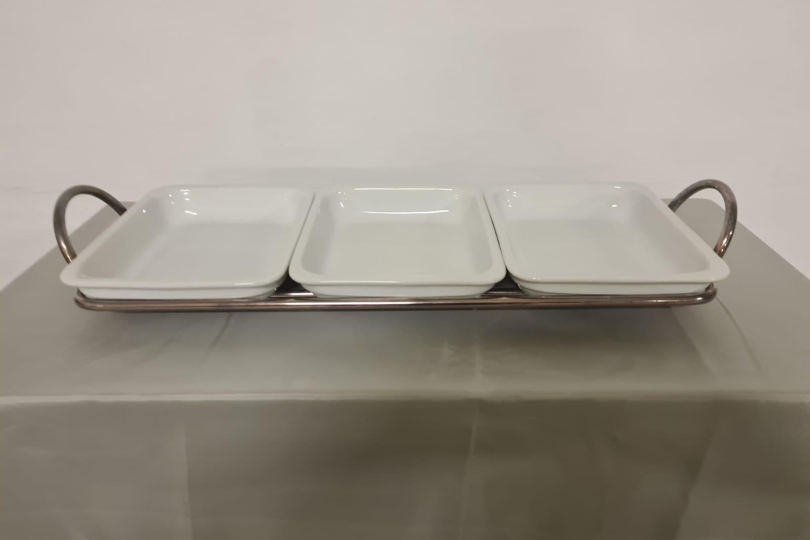 Sabonet tray appetizer.

Refined hors d'oeuvre tray.

Silver-plated metal frame divided into 3 compartments where 3 white ceramic bowls are housed.

Produced by Sambonet Italian brand founded in 1856 by goldsmith Giuseppe Sambonet.

Synonymous with