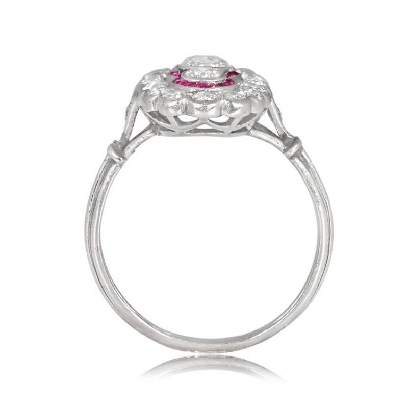 An elegant Edwardian platinum ring featuring three bezel-set old European cut diamonds arranged in a north-south orientation, encircled by natural caliber cut rubies. The diamond and ruby arrangement is framed by a halo of additional half-bezel-set