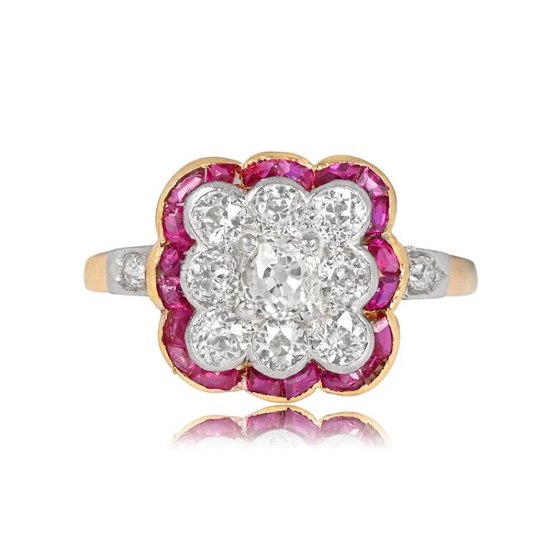 An antique platinum and 18k yellow gold ring boast a 0.20 carat antique cushion cut diamond, prong-set and encircled by half-bezel set old European cut diamonds. The floral design is outlined by calibrated natural rubies set in gold. The total