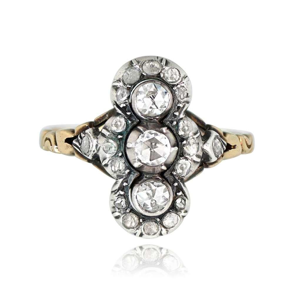 This antique Georgian ring showcases three rose-cut diamonds bezel-set in an elongated mounting. The central diamonds weigh around 0.30 carats combined and are encircled by smaller rose cuts. It features intricate hand engravings on the shoulders