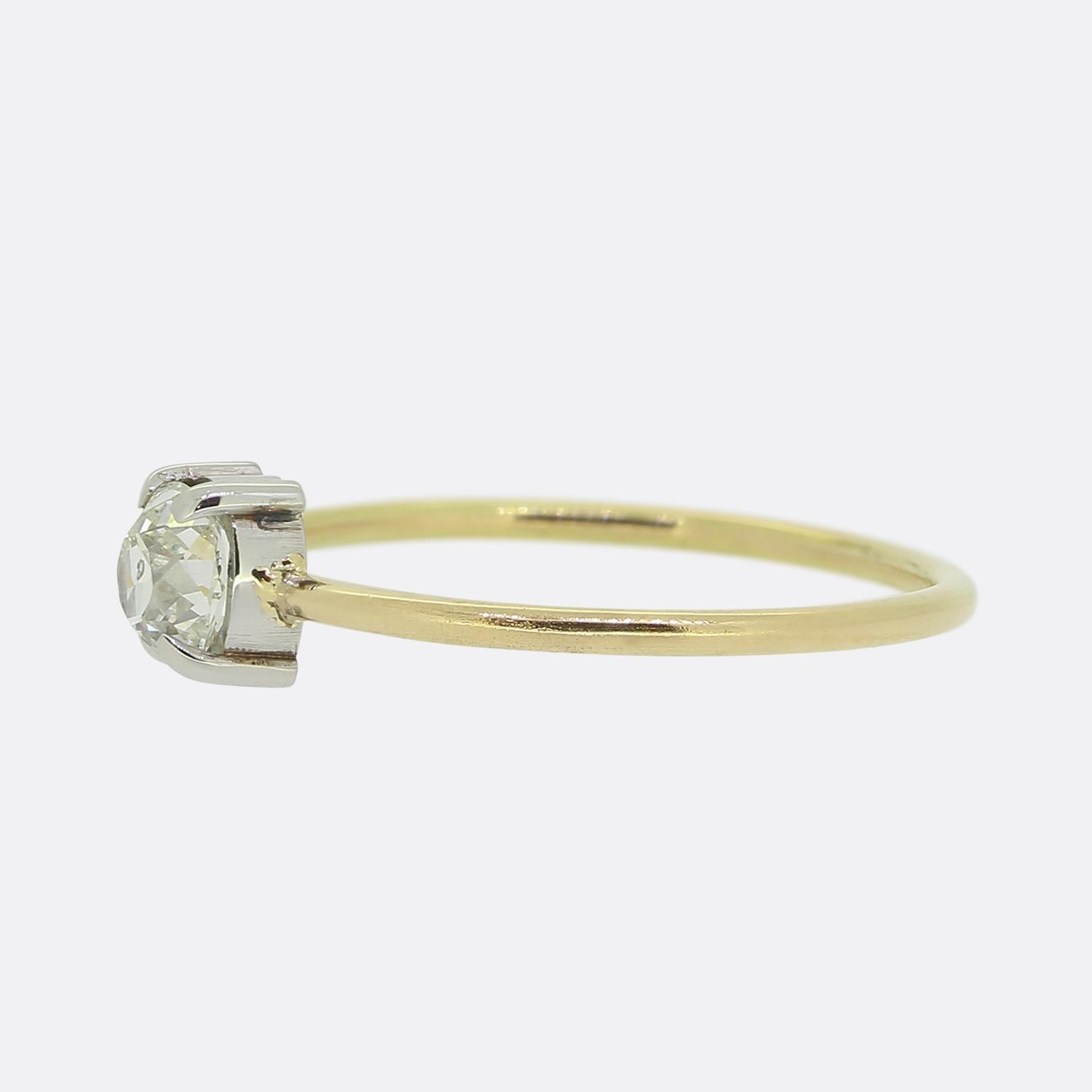 Hier haben wir einen Solitärring mit einem einzelnen Diamanten im Minenschliff in der Mitte. Dieser einzigartige Edelstein mit seinen einzigartigen Facetten ist sicher in einer Vier-Zacken-Fassung gefasst, die seine Brillanz noch verstärkt. Das Band
