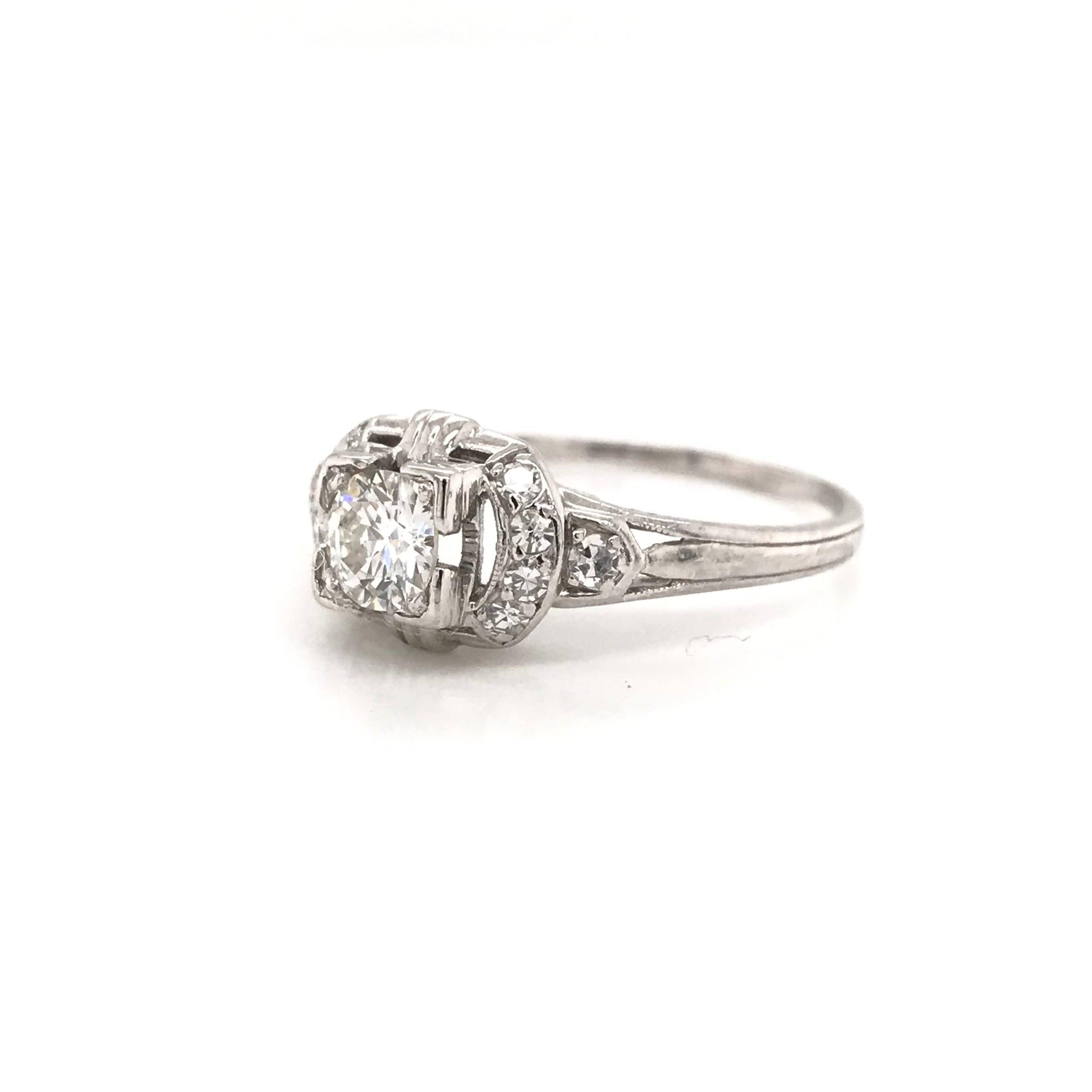 This darling antique piece was handcrafted during the early twentieth century. The dainty platinum setting features a center diamond measuring approximately 0.35 carats ( greater than one third of one carat ). The diamond grades approximately G in