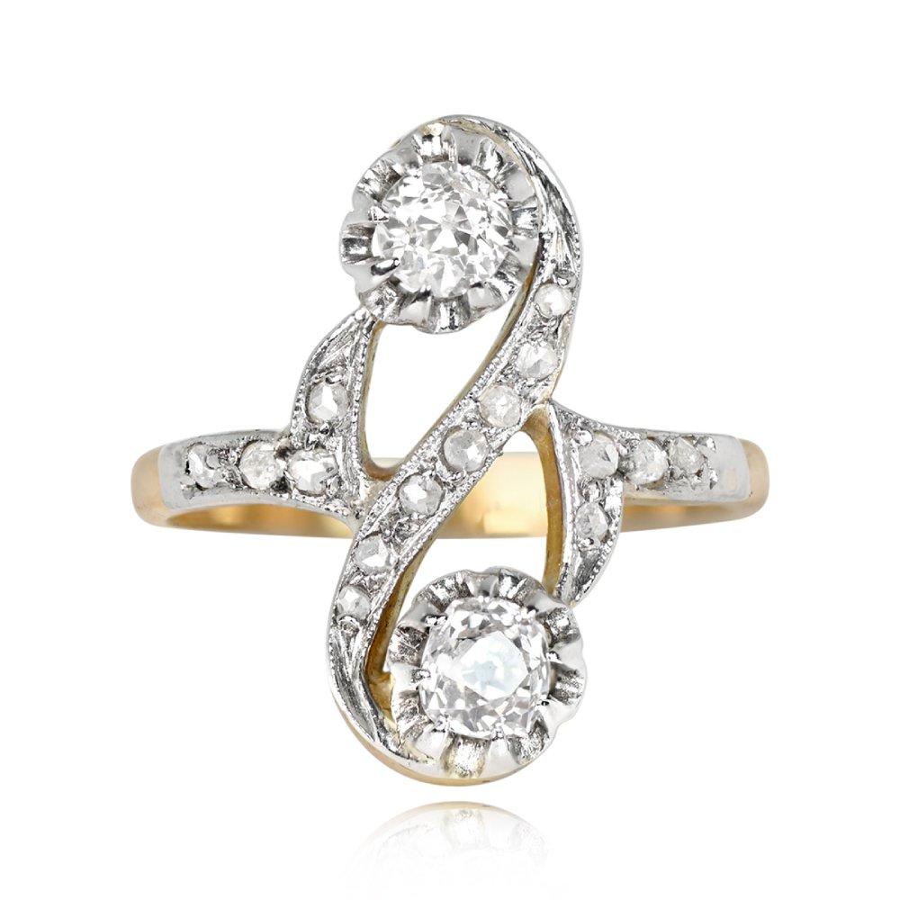 This antique Art Nouveau-era ring showcases two diamonds with a total weight of approximately 0.38 carats. One is an old European cut diamond with H color and SI2 clarity, set in yellow gold prongs, while the other is an antique cushion cut diamond