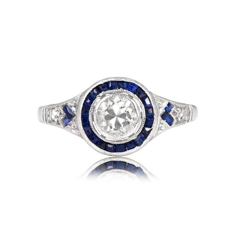 An exquisite piece from the Art Deco era, circa 1925, this ring showcases a vibrant old European cut diamond, approximately 0.40 carats, with I color and SI2 clarity, elegantly bezel-set and encircled by a captivating halo of calibre cut natural