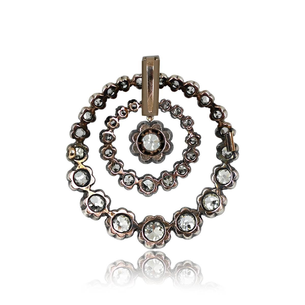 An authentic Victorian-era pendant featuring an antique cushion-cut diamond at the center, weighing approximately 0.50 carats, surrounded by two rounds. Crafted in silver on gold, this exquisite brooch dates back to the 1880s.
The total approximate