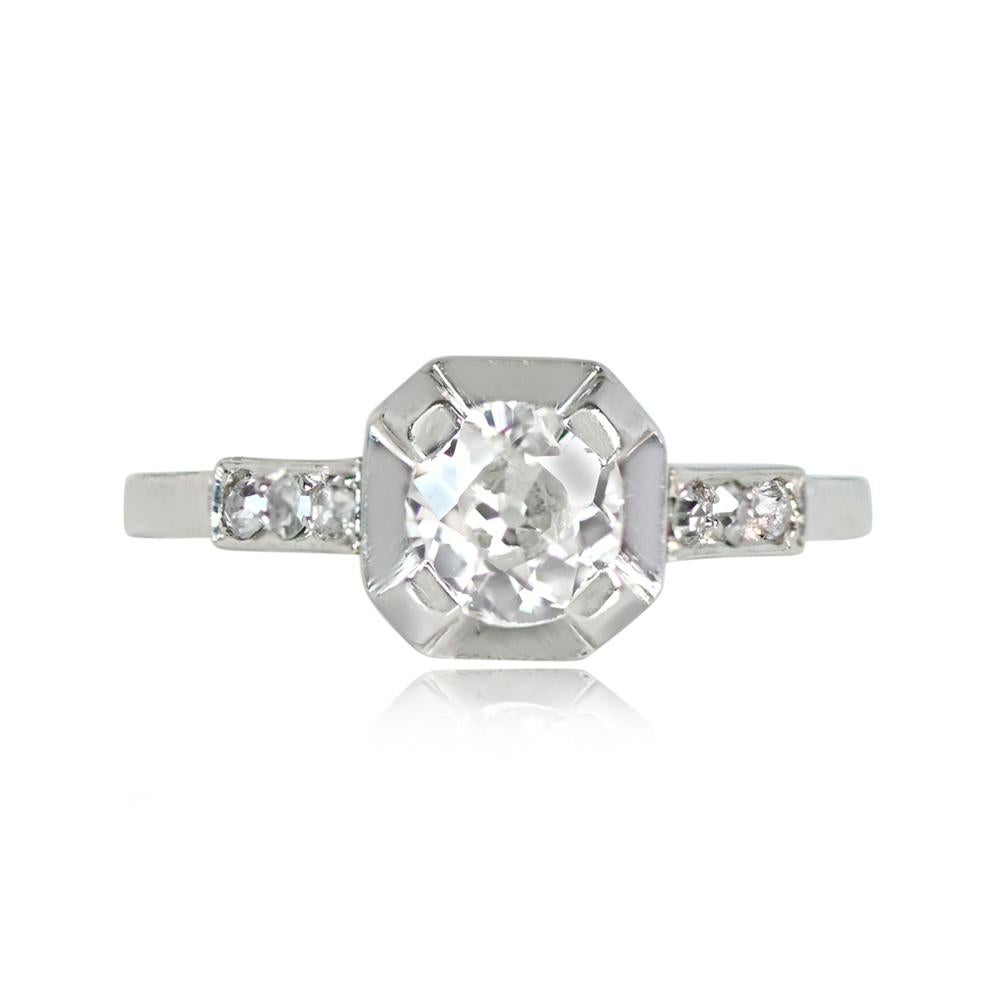 An exquisite antique Art Deco engagement ring, handcrafted in platinum in France. The centerpiece is an antique old European cut diamond, approximately 0.65 carats, with J color and VS2 clarity. Adorning the shoulders are smaller diamonds with a