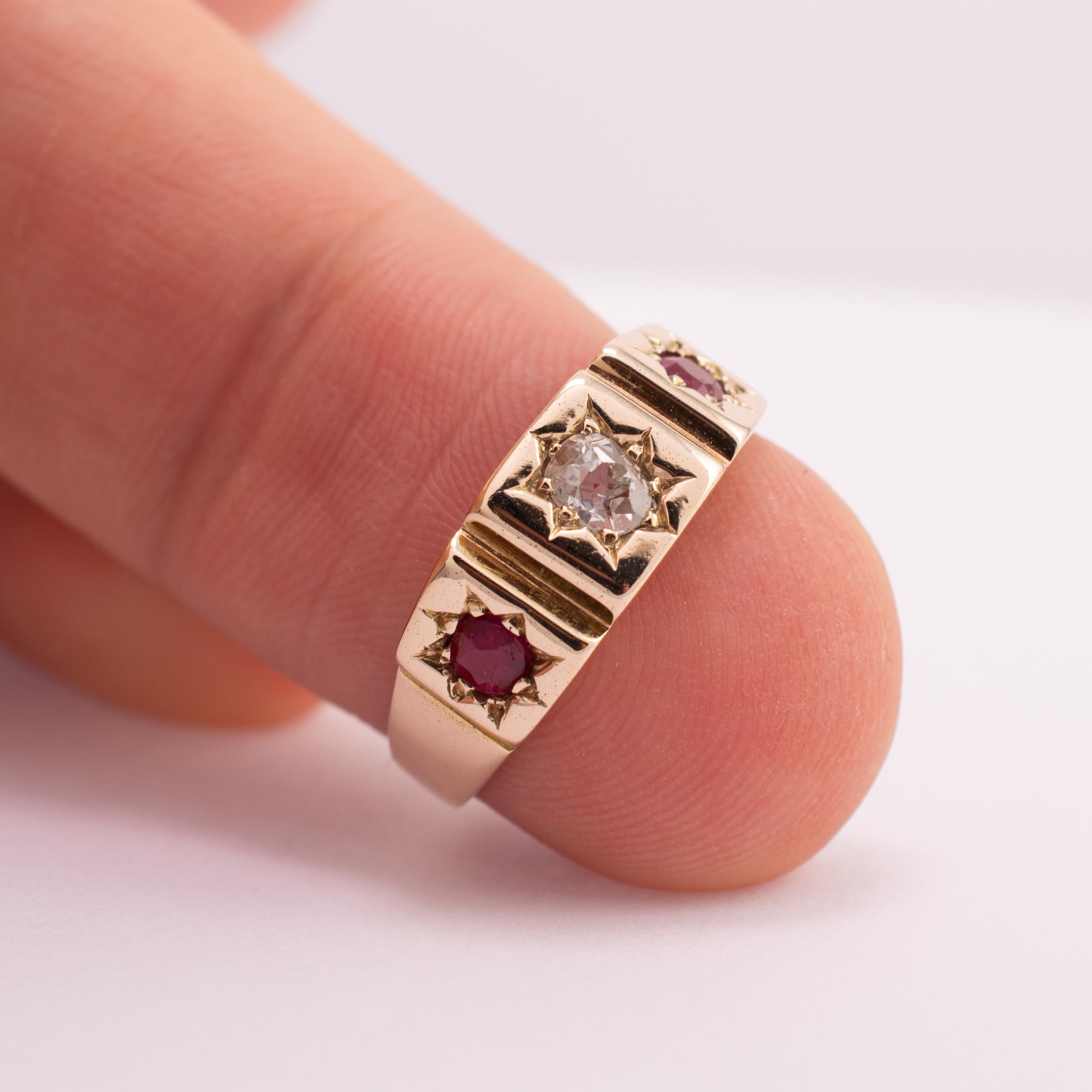 This fine quality antique ruby and diamond ring is crafted in 18 karat gold.

The substantial ring features 1 old cut diamond to the center and flanked either side by rubies. All three gemstones set in stars within individual squared panels to give
