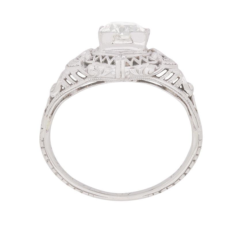 This 1920s, a distinctive Jazz Age jewel features a lively 0.90 carat old cut diamond in richly-detailed 18 carat white gold. Stunning period elements abound in the ring's original setting with its unique combination of filigree work and