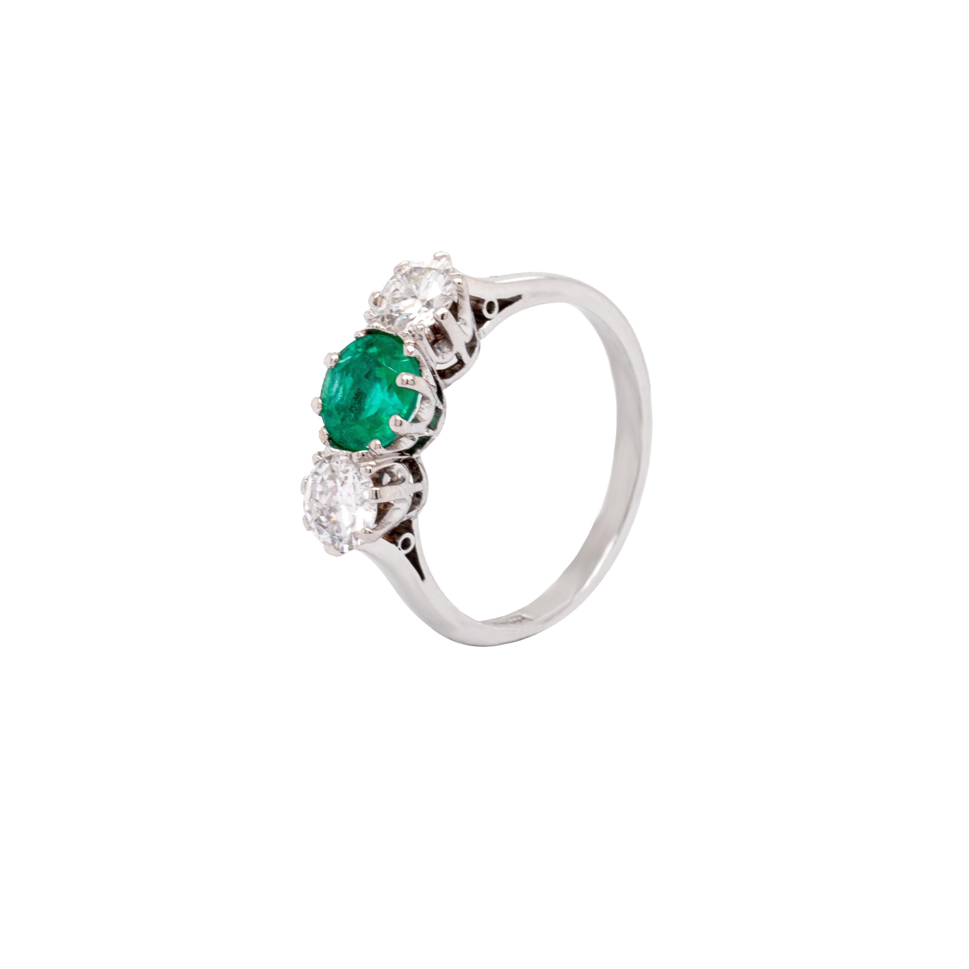 This gorgeous antique three-stone emerald and diamond ring is elegant and timeless.

The intense saturation of colour in the emerald is sublime, and the beautiful round-cut stone weighs a generous 0.95 carats. The emerald is accompanied by a