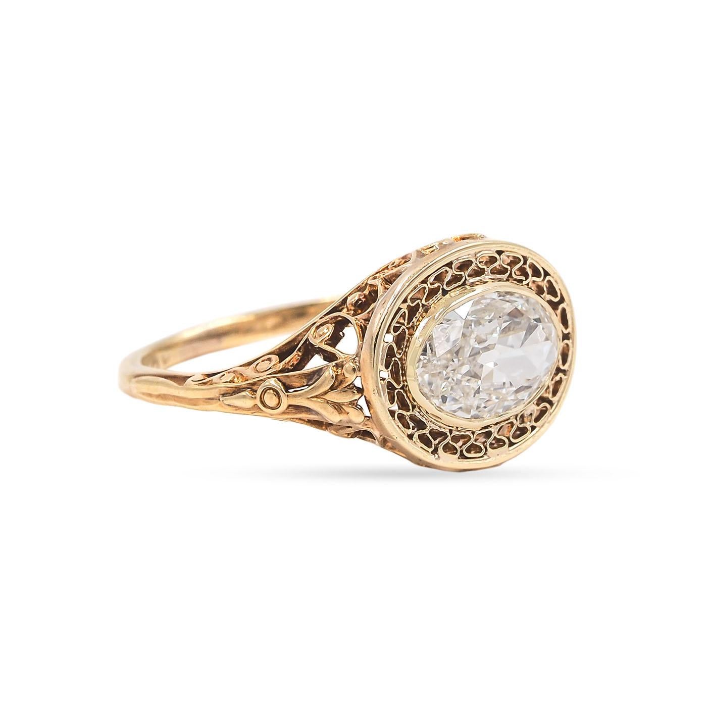  Early Edwardian era 1.03 Carat Antique Oval Cut Diamond Engagement Ring composed of 14k yellow gold. The 1.03 carat Oval Cut diamond is GIA certified G color/VVS2 clarity. In an oval East/West (horizontal) setting, with ornate pierced cut-out