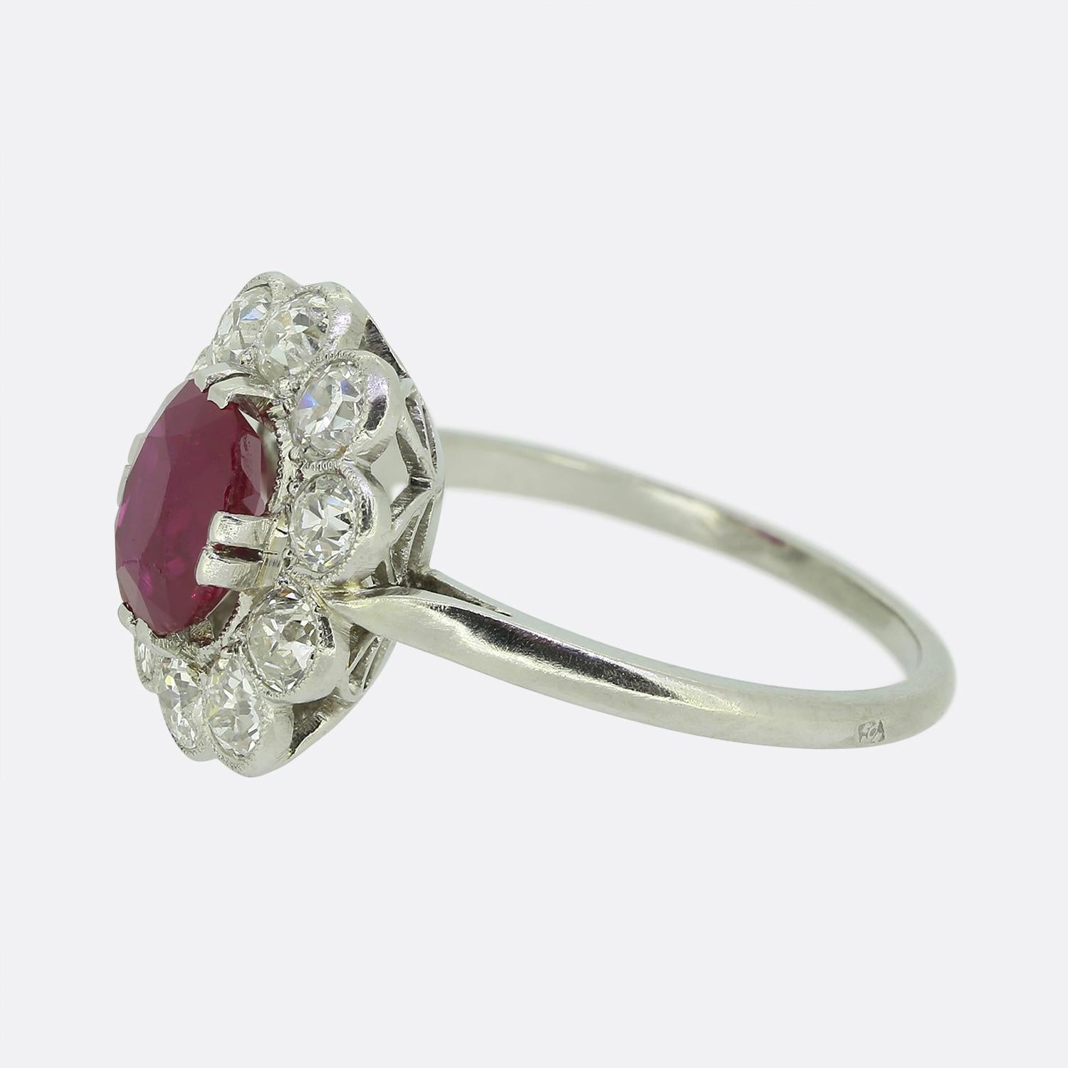 Aquí tenemos un precioso anillo en racimo tomado de una época en la que el estilo Art Déco estaba en la cima del diseño mundial. Elaborado en platino, presenta un cautivador rubí de talla ovalada en el centro, que irradia un tono rojo intenso con un