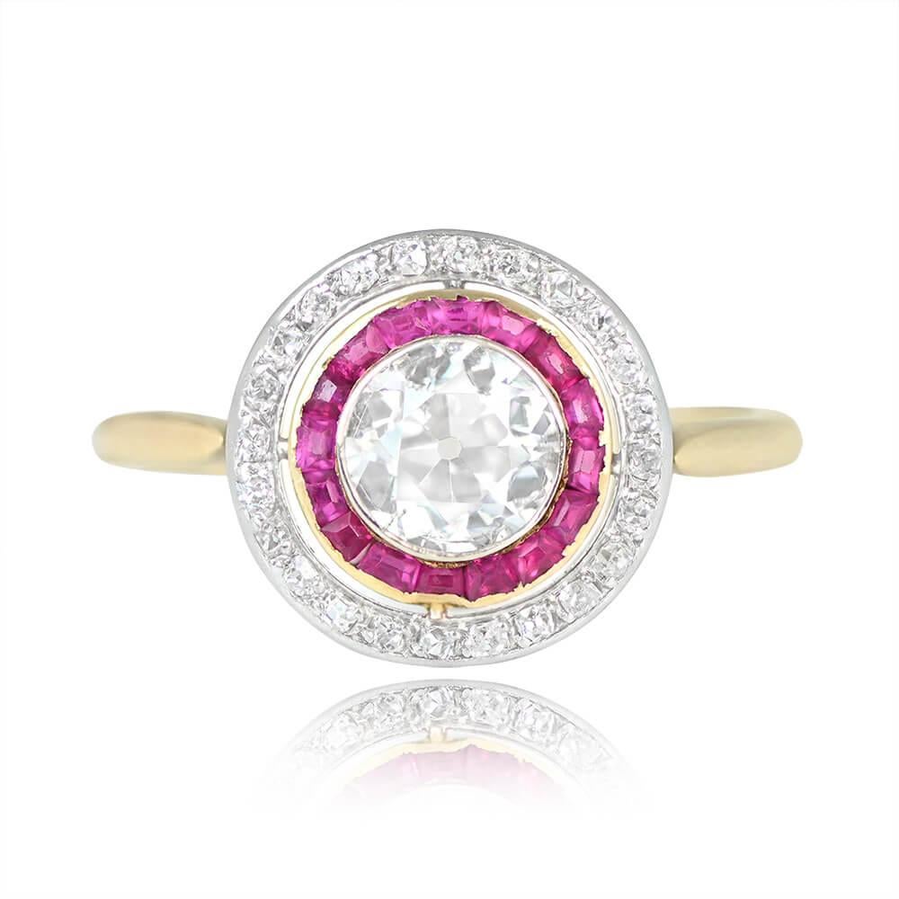 This Edwardian-era antique ring features a central 1.00-carat old European cut diamond with I color and SI2 clarity, set in a bezel. The diamond is accentuated by a double halo, with caliber rubies surrounding the center stone and a second halo of
