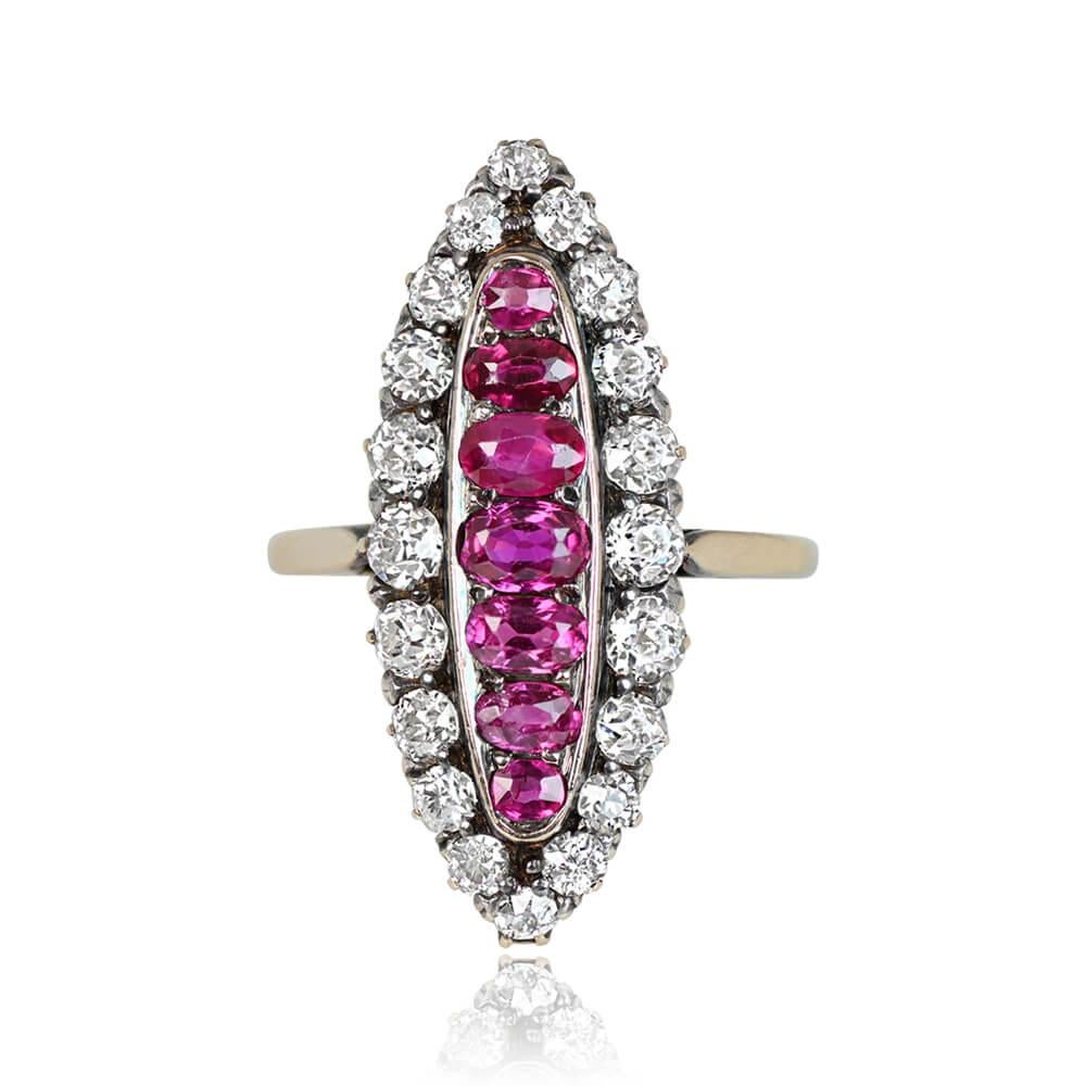 A navette ring crafted in silver on 18k yellow gold, showcasing a row of natural oval cut Burmese rubies arranged in an east-west orientation, totaling around 1.00 carat. An elongated halo of old European cut diamonds set in prongs surrounds the