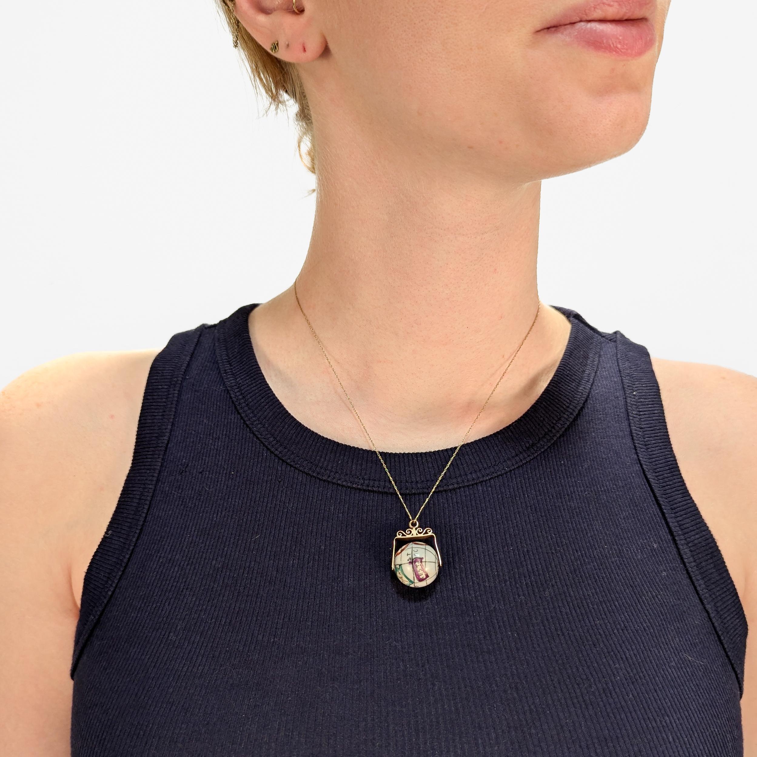A fine antique gold & porcelain spinner pendant or charm for a bracelet.

In the form of a porcelain bead decorated with a polychrome, simplified map of the world.

Set with a 10 karat rose gold yoke. 

Perfectly sized for use as a pendant for a