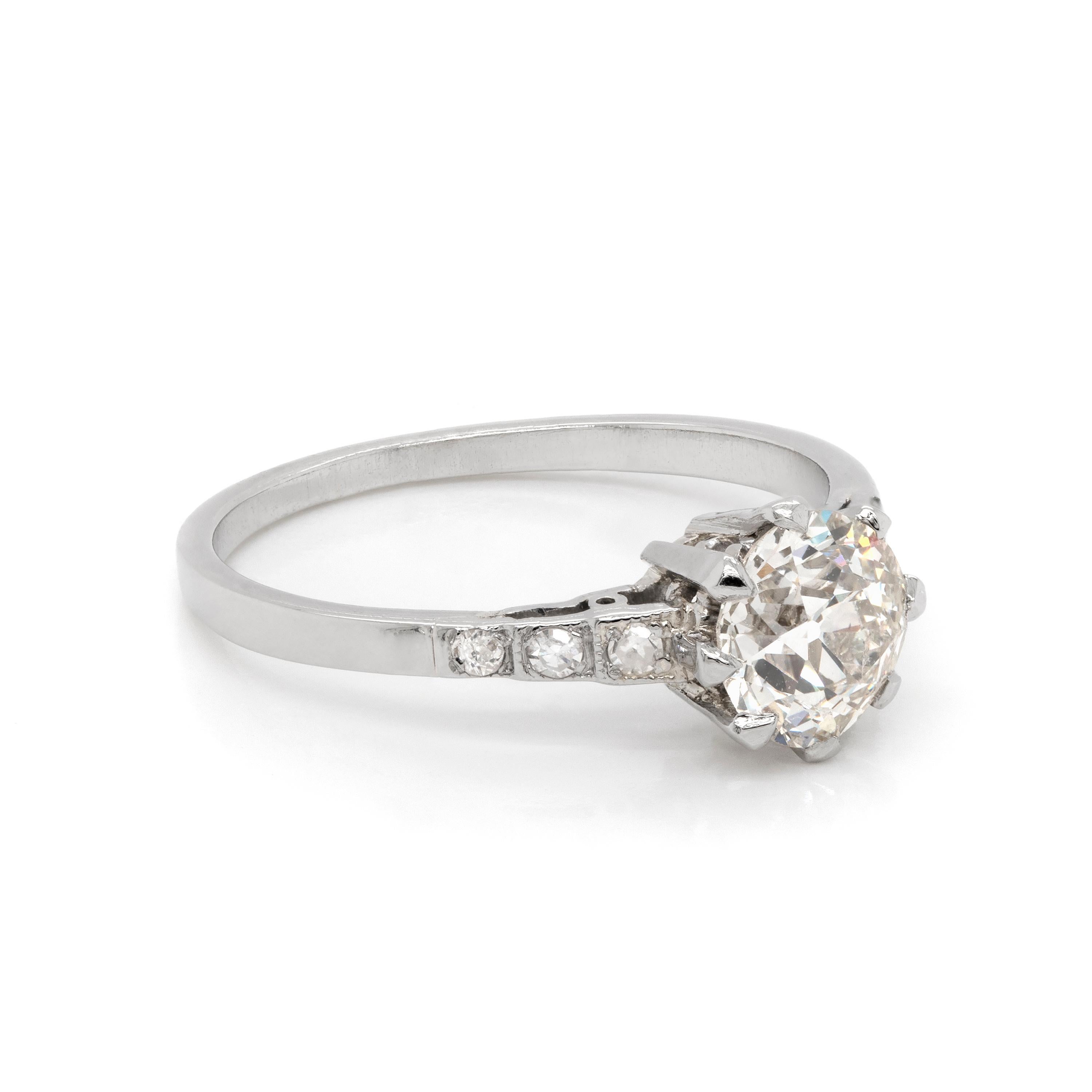This beautiful antique engagement ring features a 1.15ct old mine cut diamond in the centre, set in an eight claw, open back platinum mount. The shoulders are set with three old European cut diamonds on either side, weighing approximately 0.10