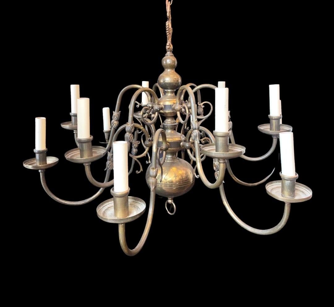 Rare Mid 20th Century Antique Original 12 Arm Brass Flemish Chandelier.

The chandelier is a classic flemish style chandelier, made of bronzed brass with a beautiful curved body centre and doubled headed eagle at the very top of the body. The body