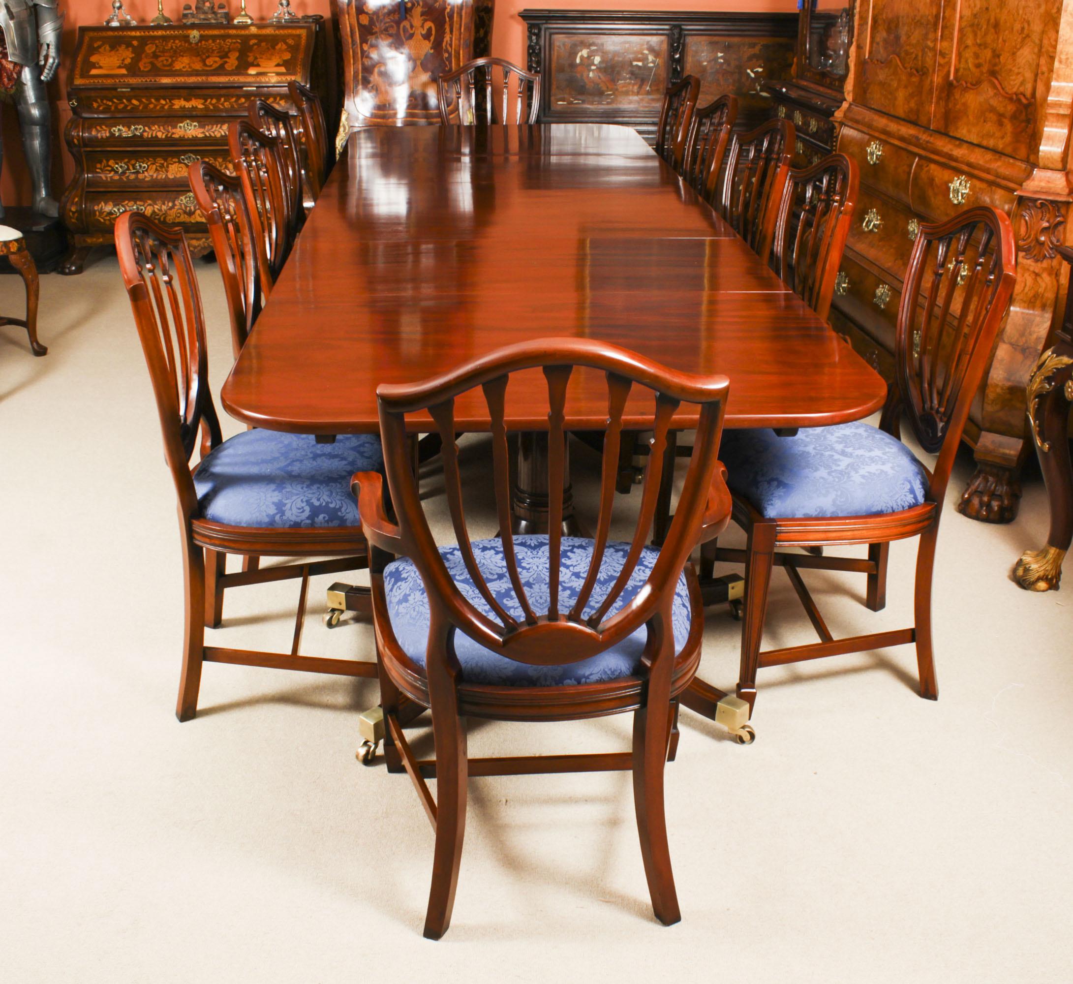 This is an elegant antique dining set that comprises an antique Regency Revival dining table dating from the 19th Century and a set of twelve Hepplewhite dining chairs.

The table has two leaves which can be added or removed as required to suit