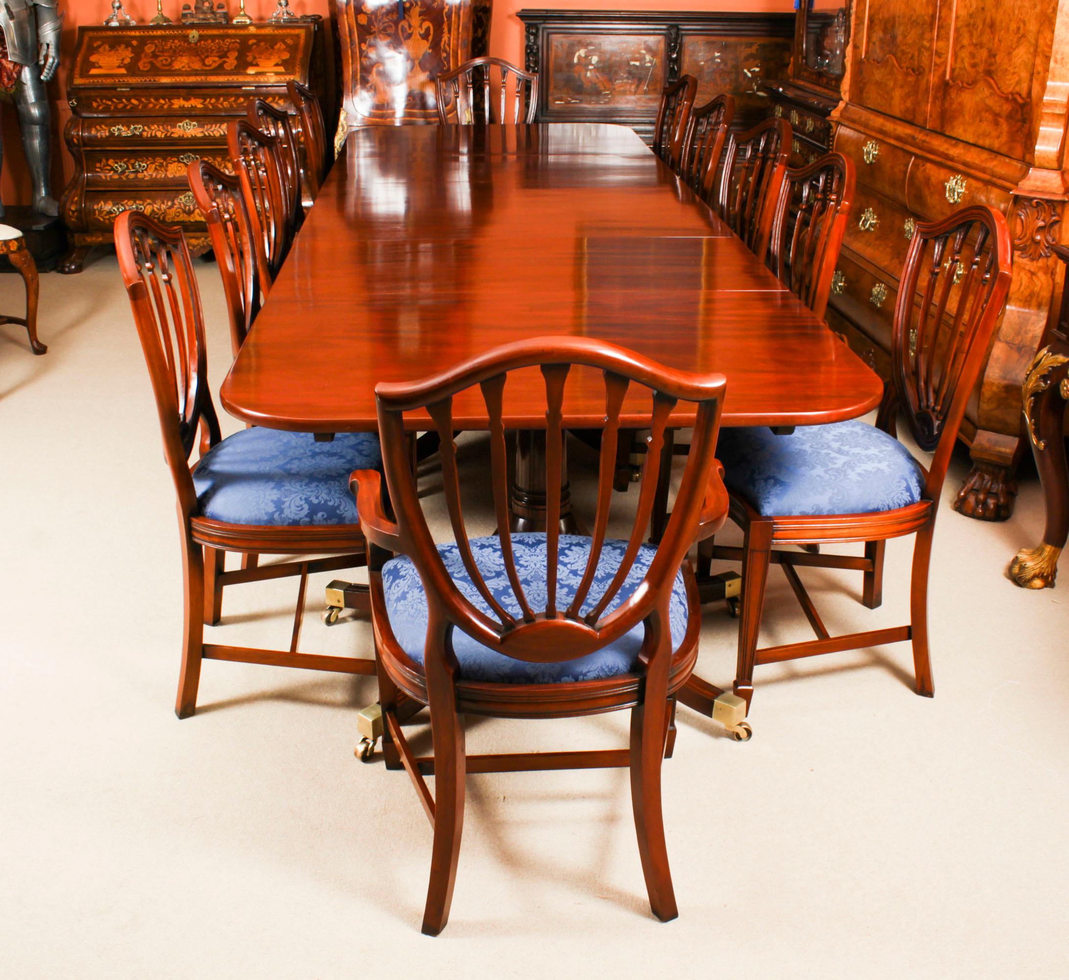This is an elegant antique  dining set that comprises an antique Regency  triple pillar dining table dating from C1830 and a set of twelve Hepplewhite  Revival 20th C dining chairs.

The table has two leaves which can be added or removed as required